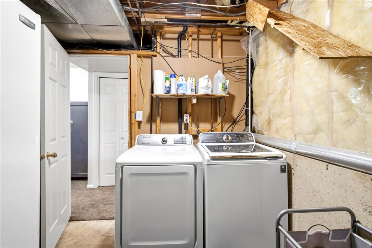 Dedicated laundry area featuring a white front-load washing machine and a white top-load washing machine