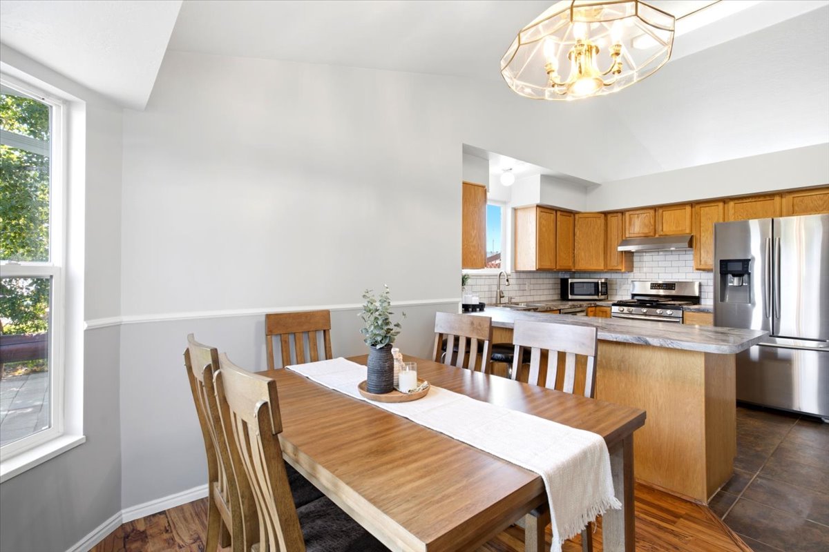 Dining area with vaulted ceiling and wood-finish flooring