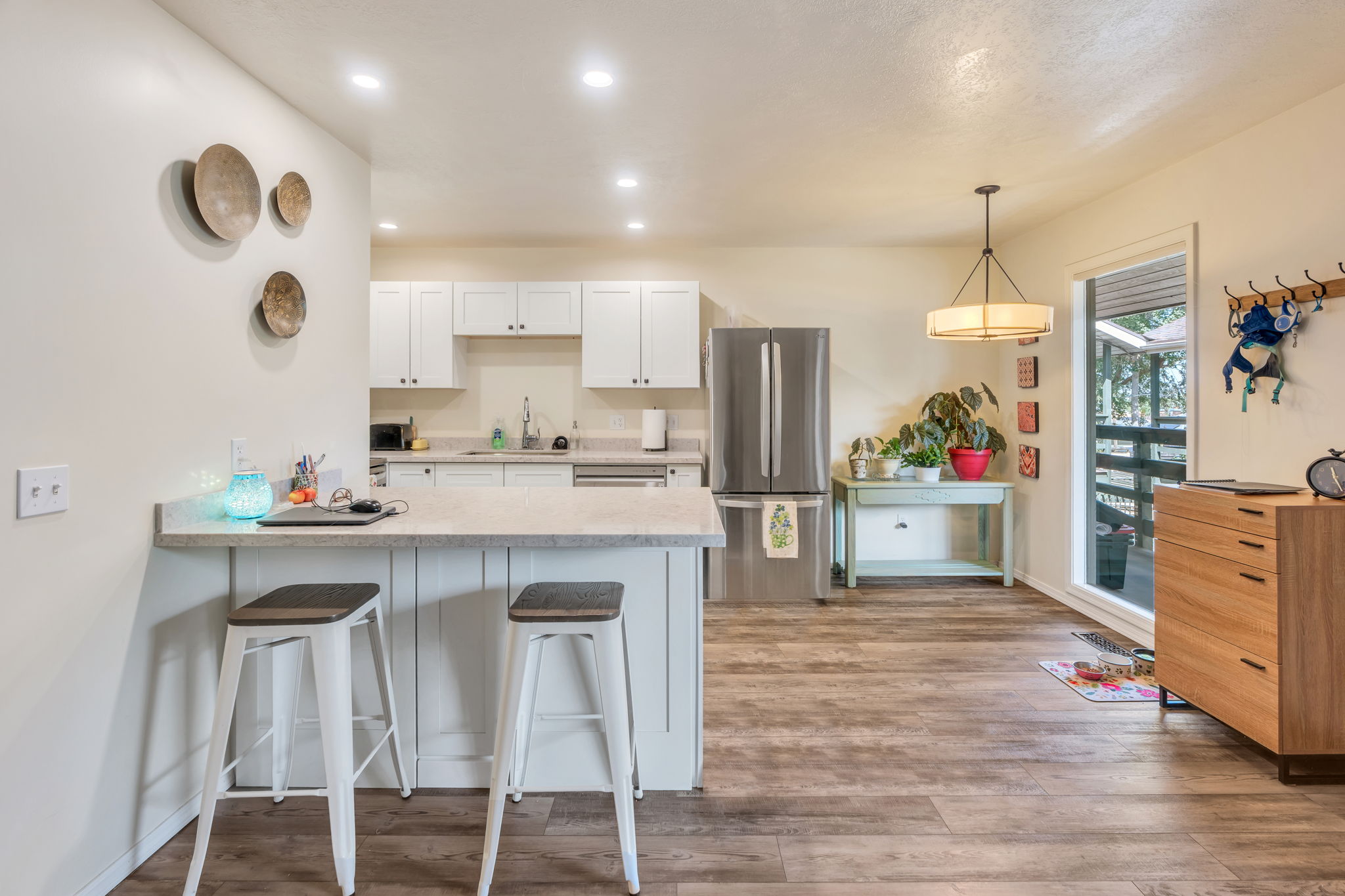 Kitchen featuring white cabinetry, stainless steel refrigerator, and light-toned countertops