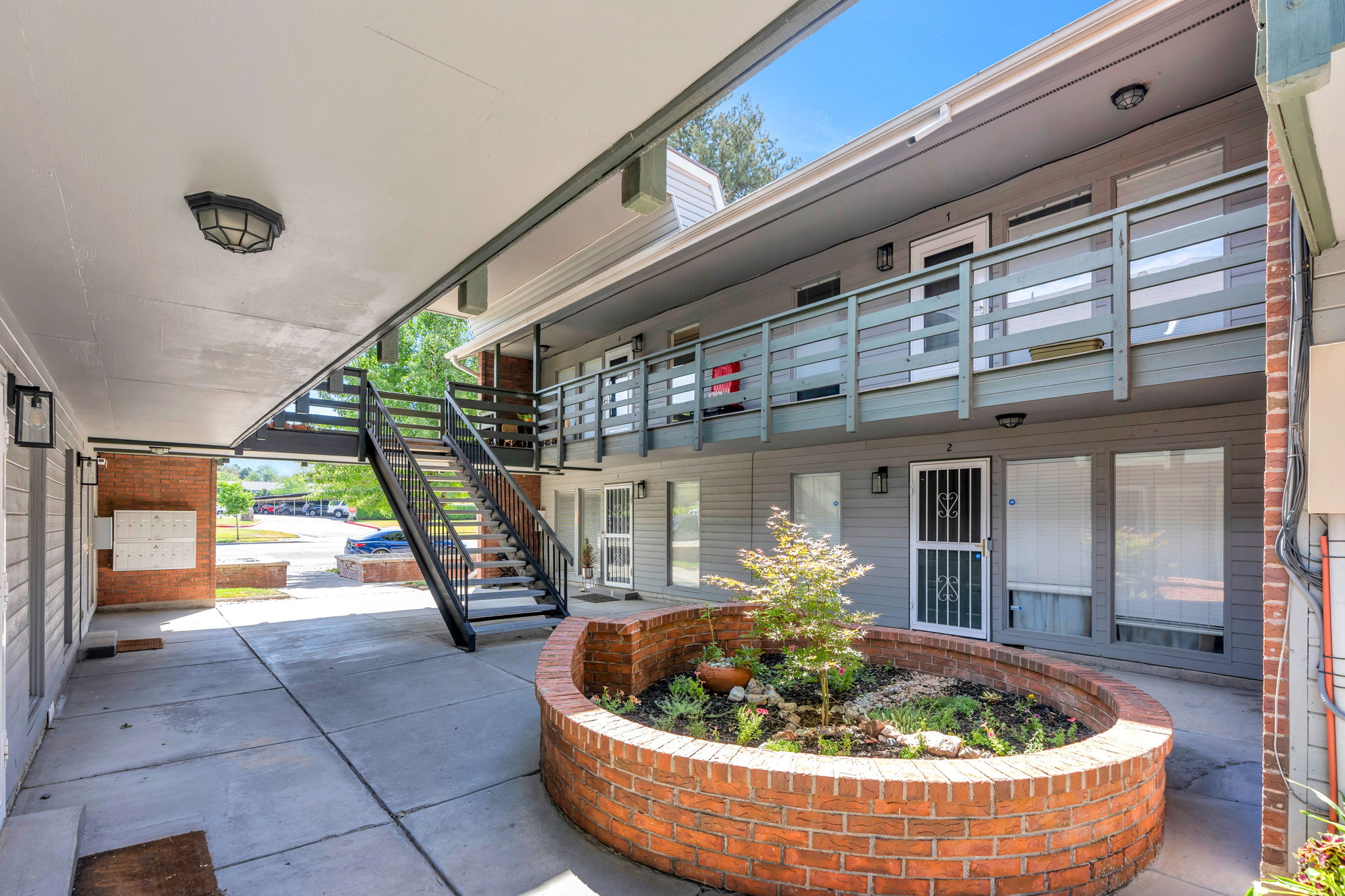 Multi-level apartment building featuring gray siding and white trim