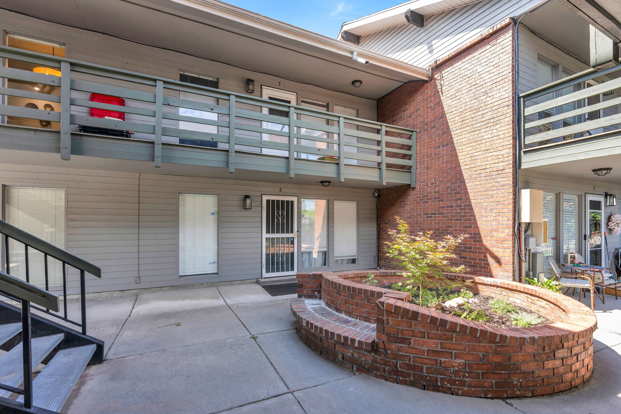 Multi-level building exterior featuring horizontal siding and brick accents