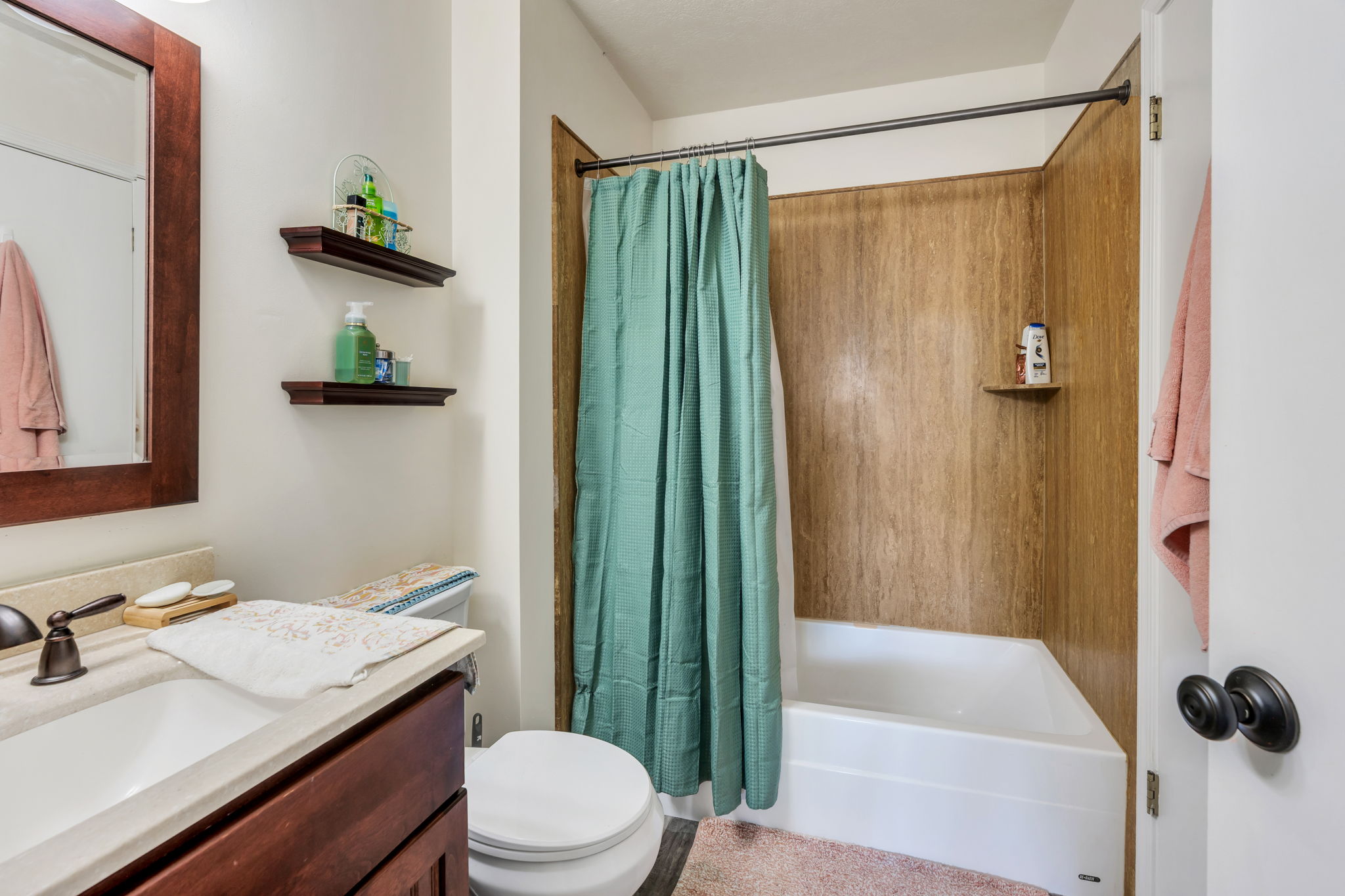 Bathroom featuring a single vanity with dark wood cabinetry, a light-toned countertop, and a white integrated sink