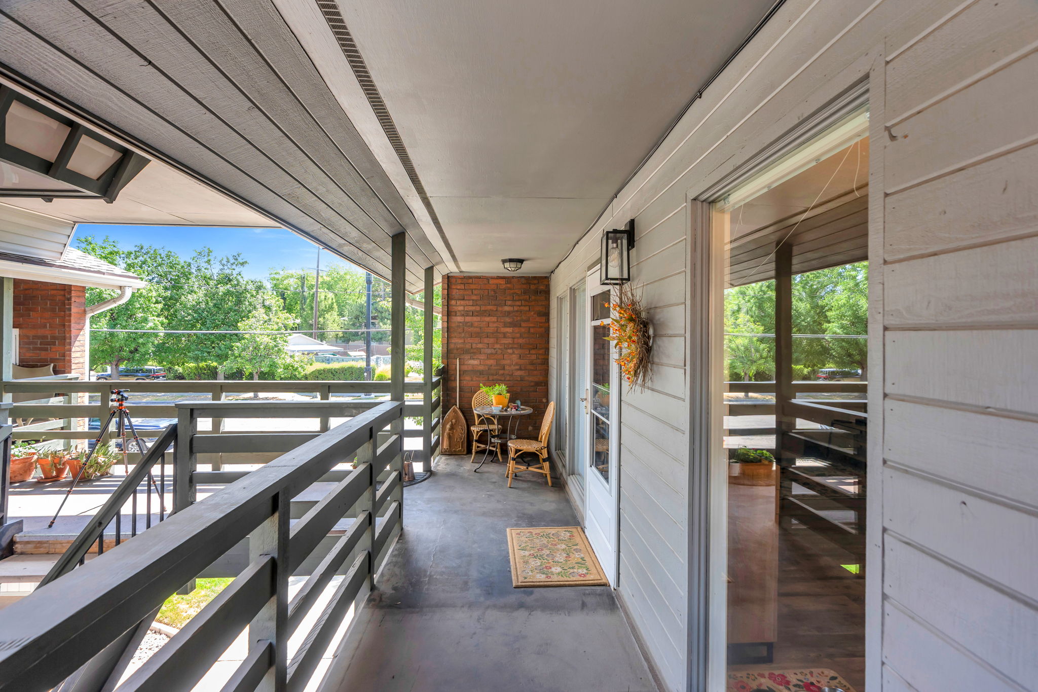 Covered porch featuring a painted wood plank ceiling and painted horizontal slat railing
