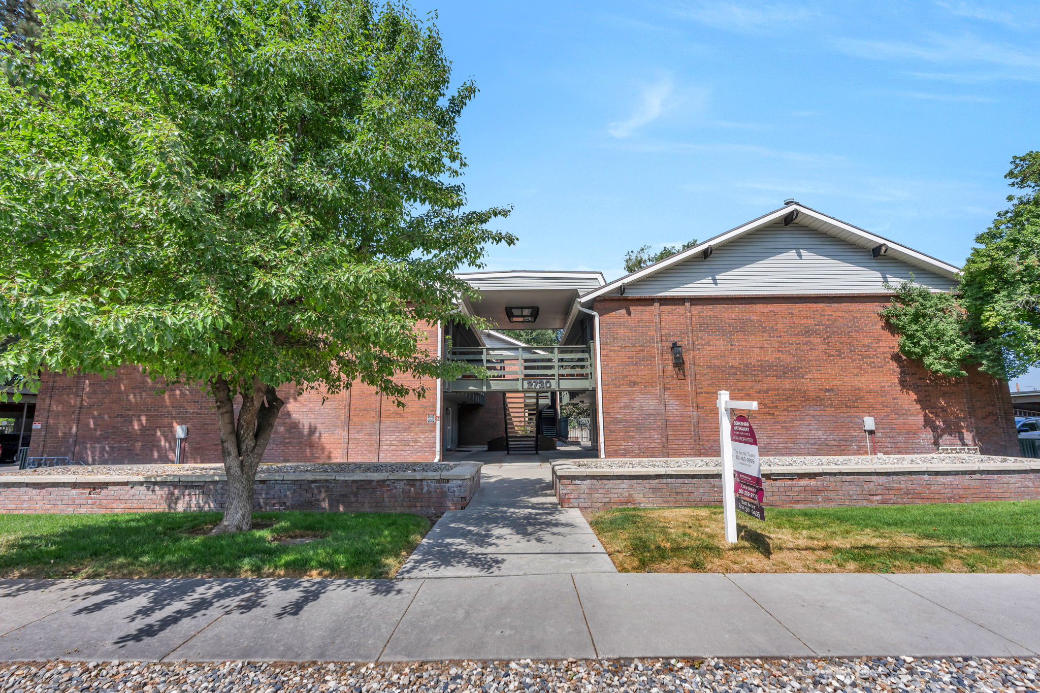 Brick exterior building with gabled roofline and light gray siding