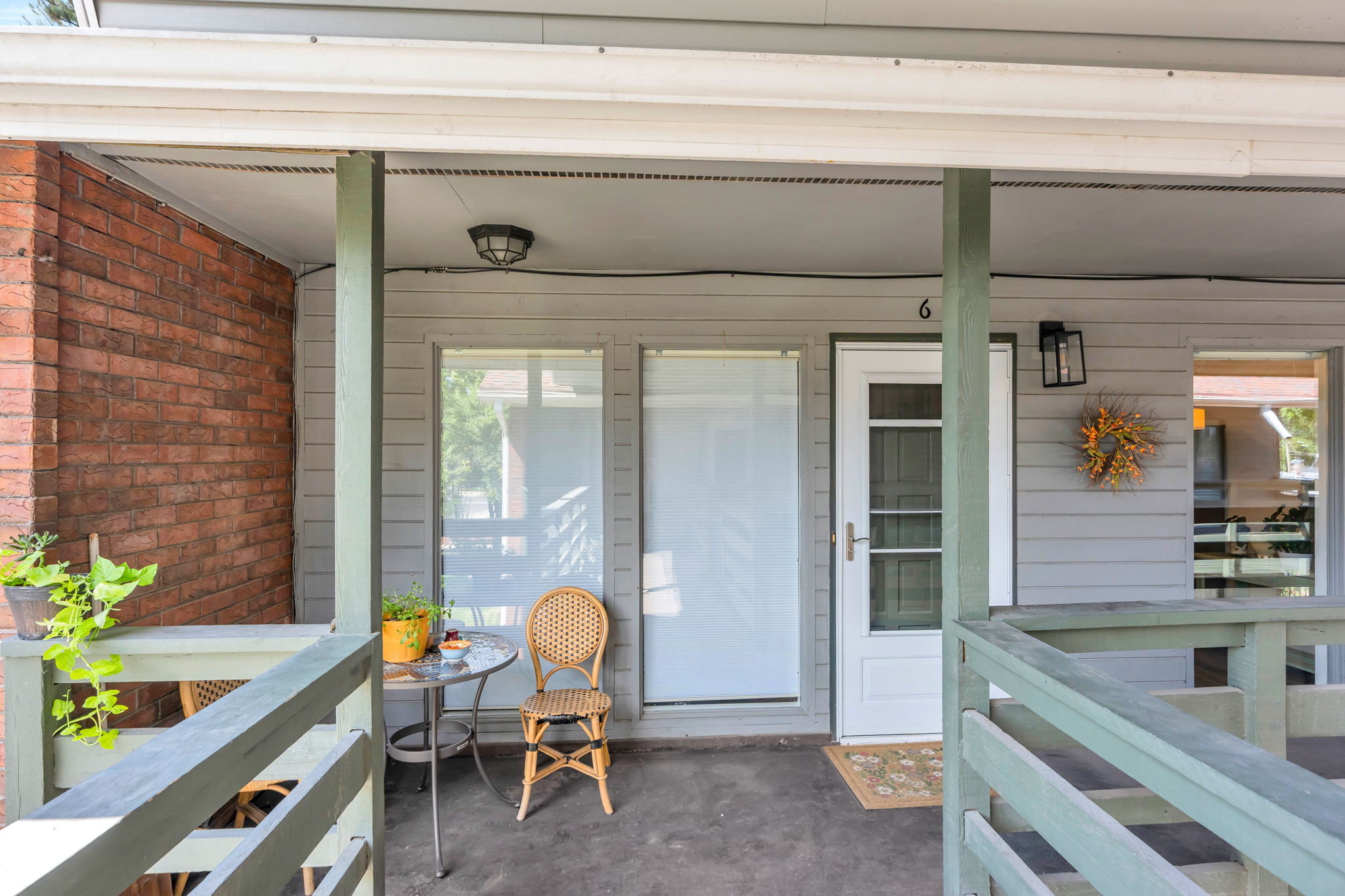 Covered entry featuring a white door with partial glass, sidelight window, and an overhead light fixture