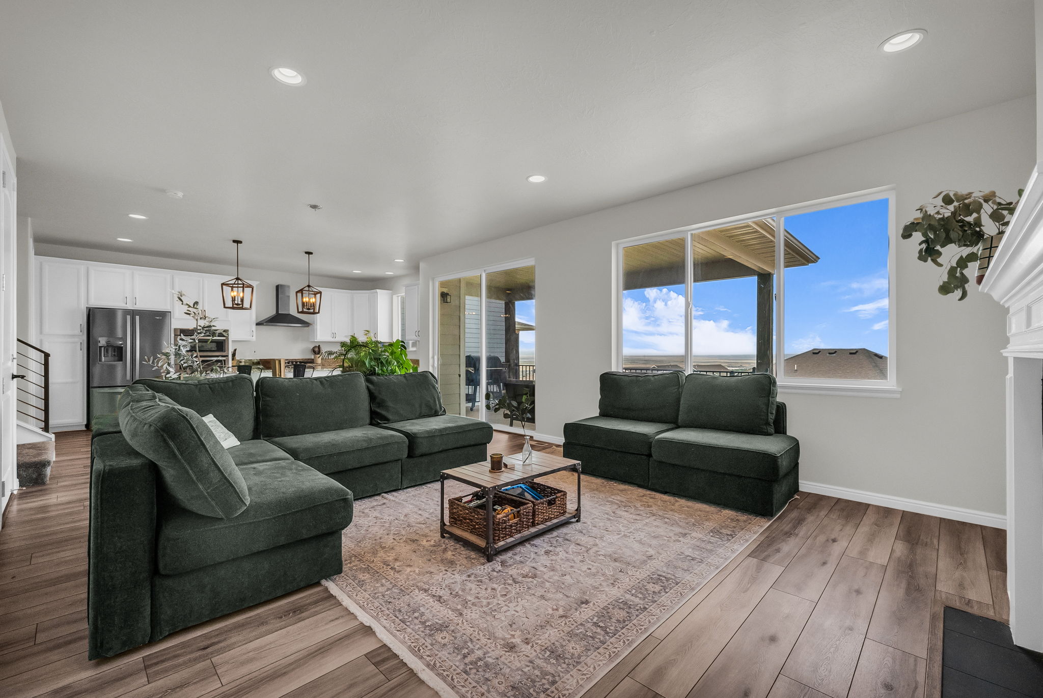 Spacious living area featuring wood-finish flooring and a white-mantled fireplace