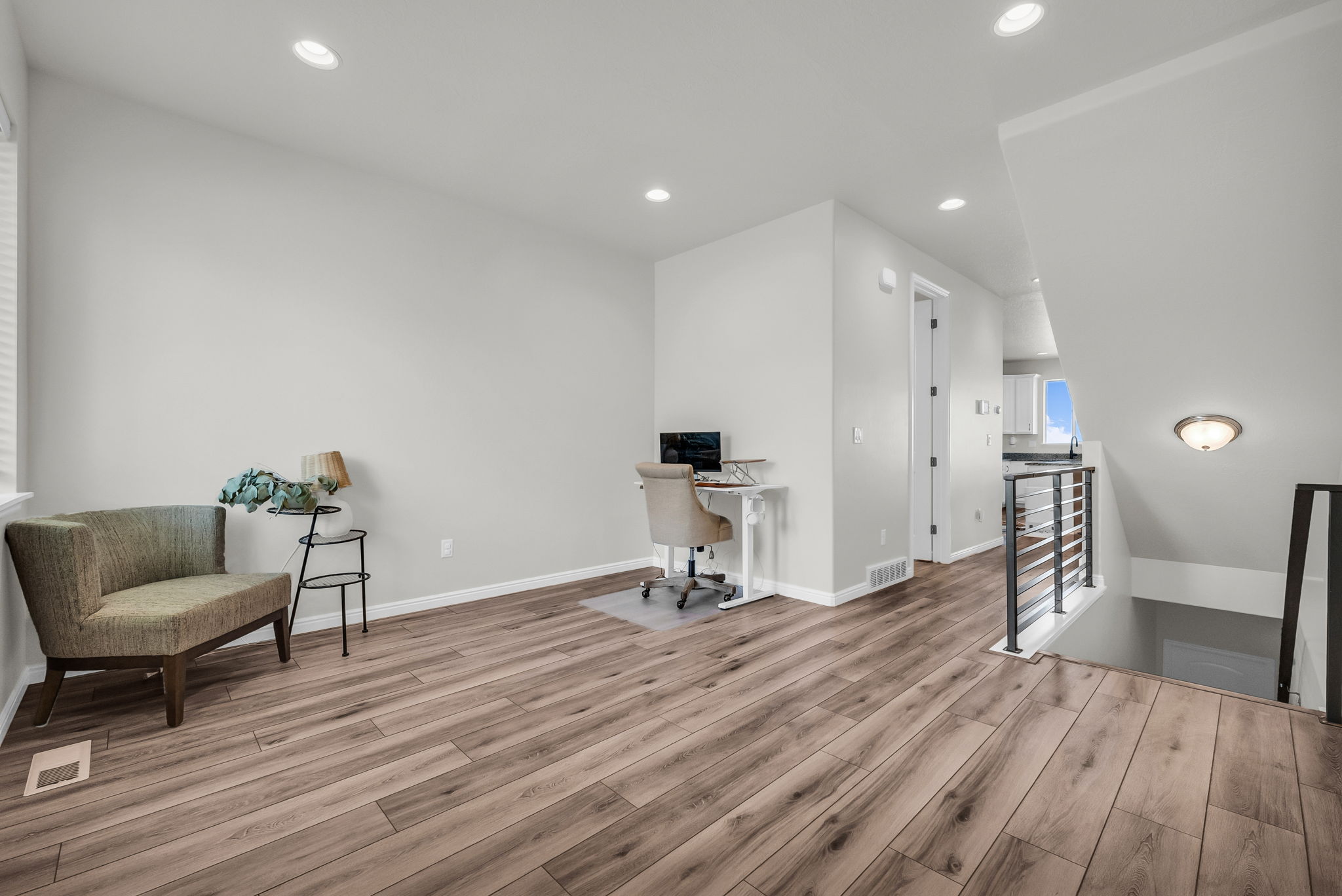 Spacious room featuring wood-finish flooring, recessed lighting, and a neutral color palette