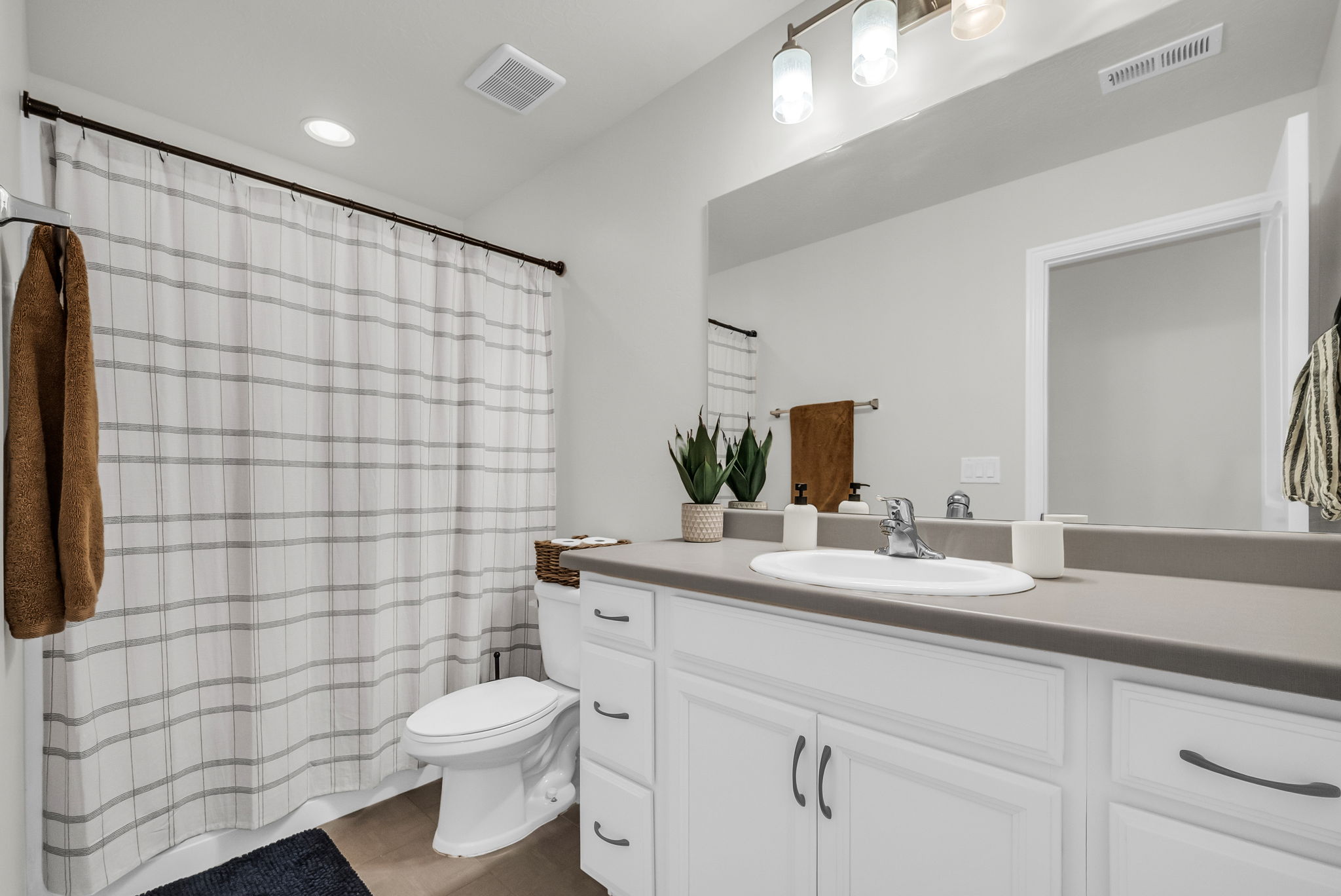 Bathroom featuring a single vanity with white cabinetry, a gray countertop, and an integrated sink