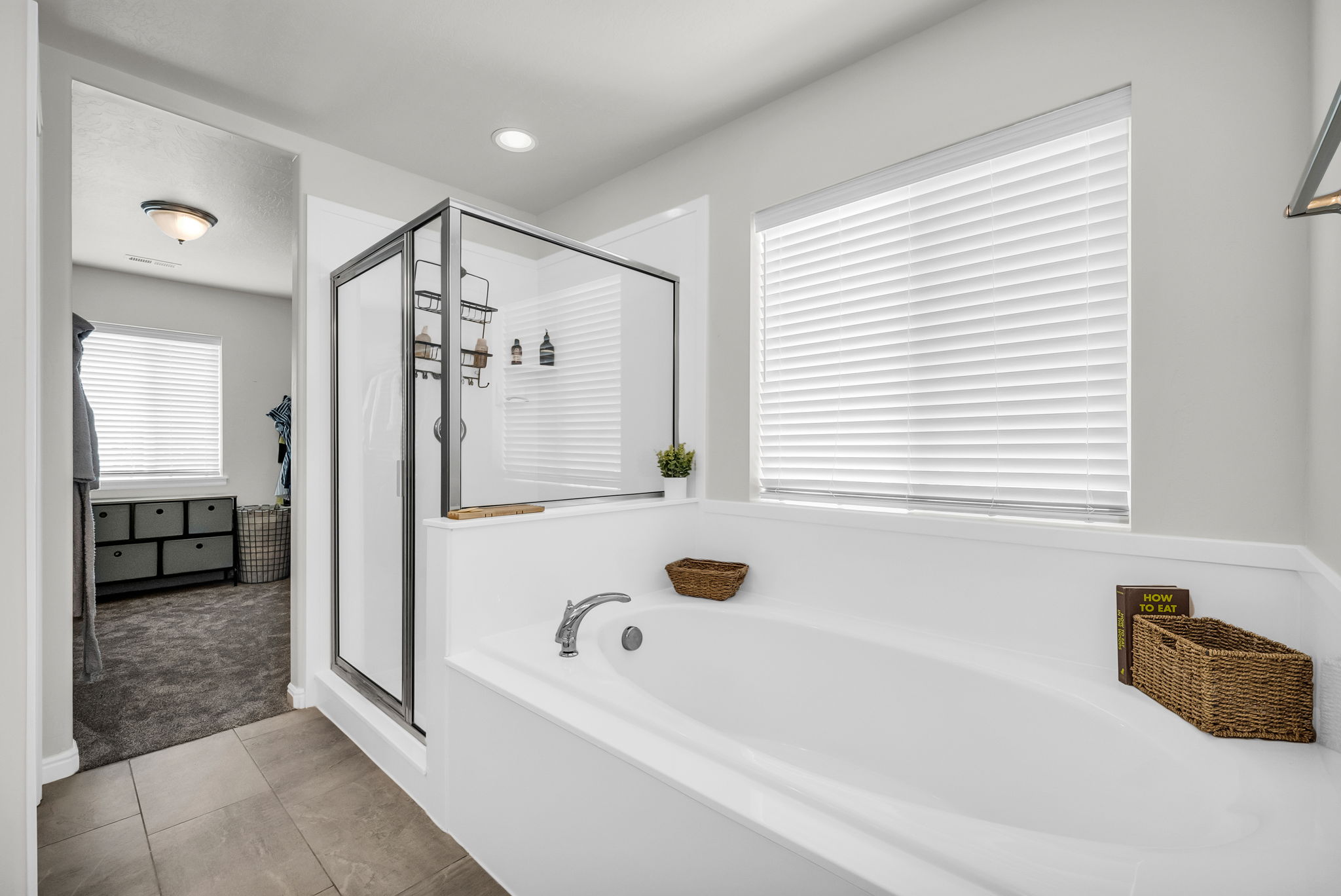 Soaking tub with deck-mounted faucet and adjacent glass-enclosed shower