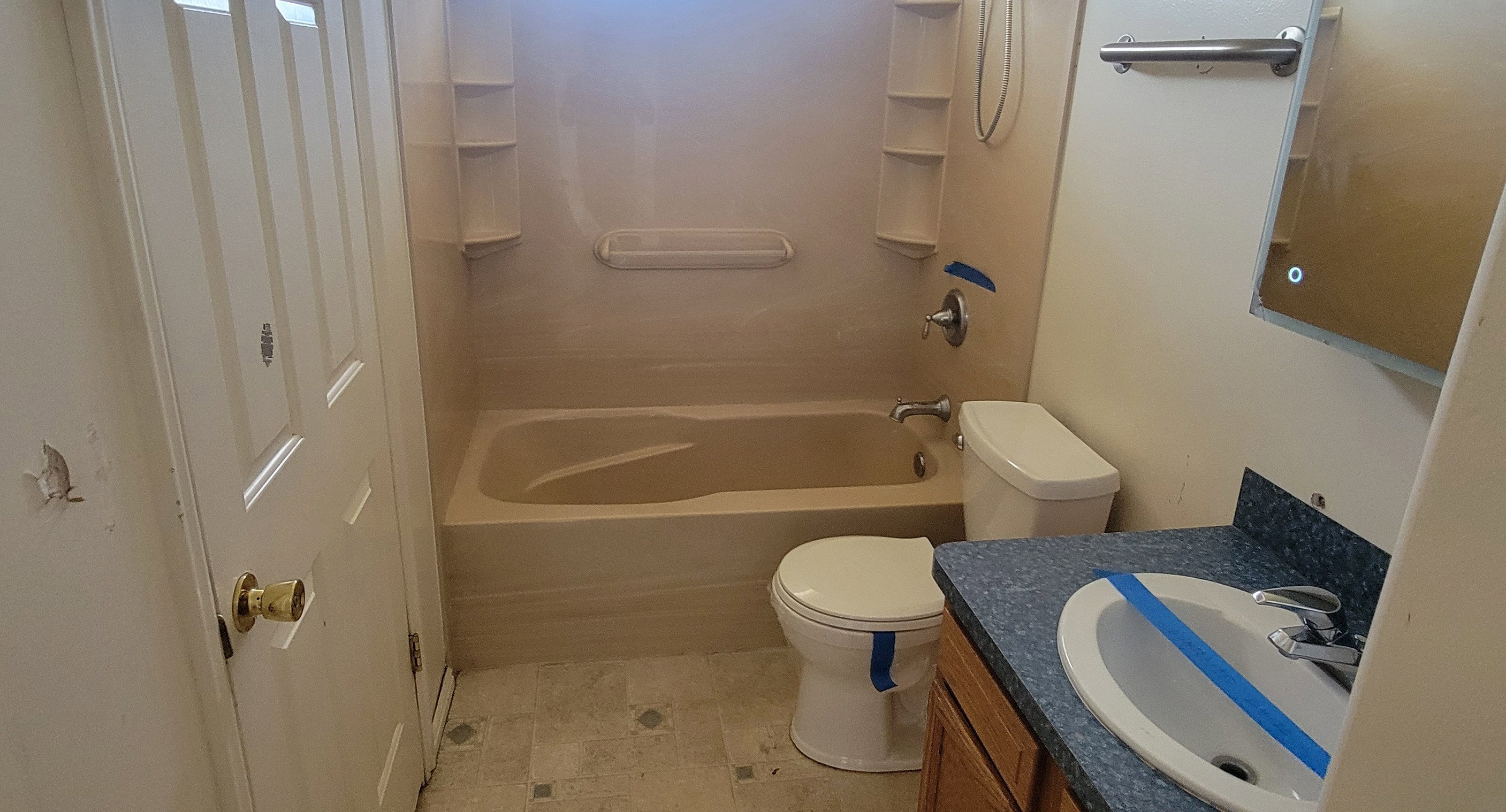 Bathroom featuring a built-in bathtub, a toilet, and a vanity with an integrated sink