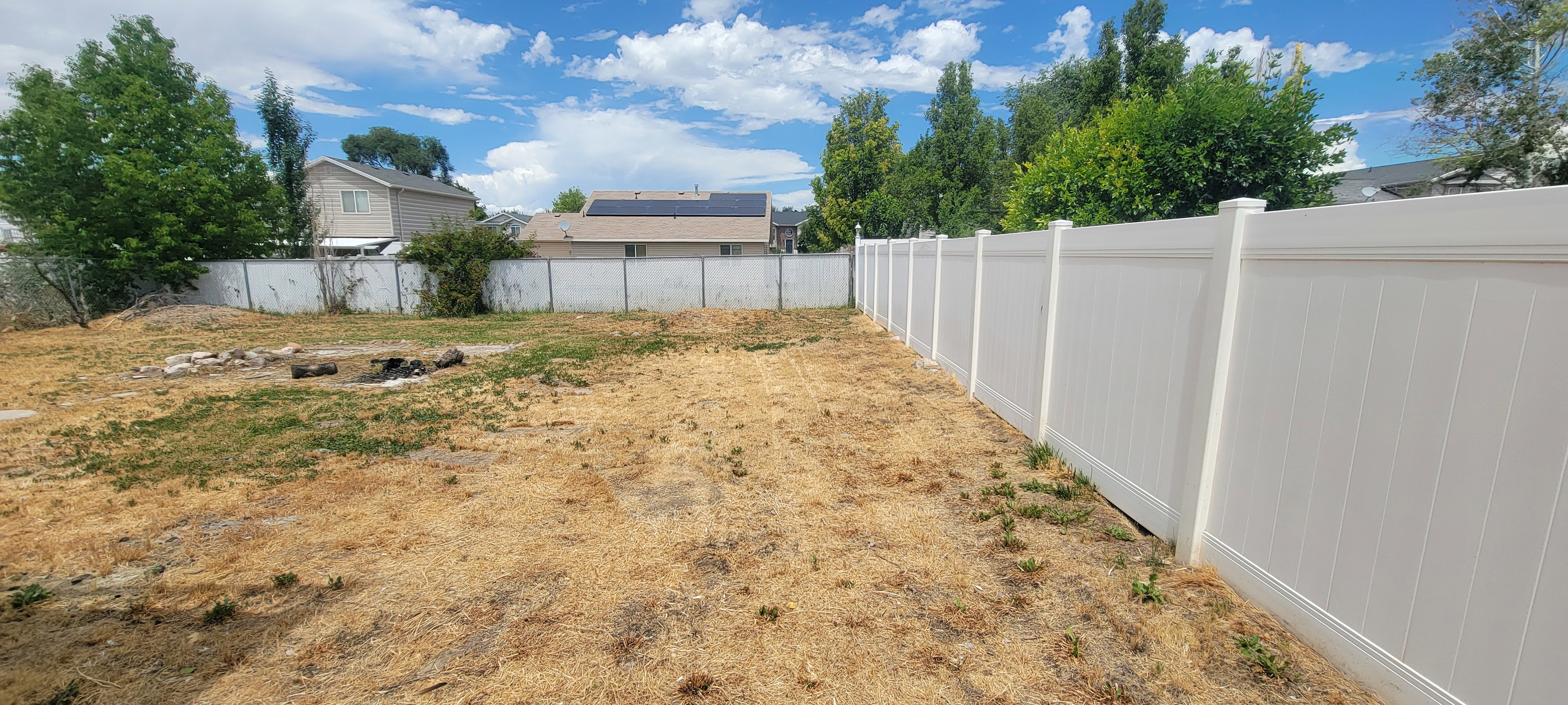 Expansive outdoor space featuring a new white privacy fence