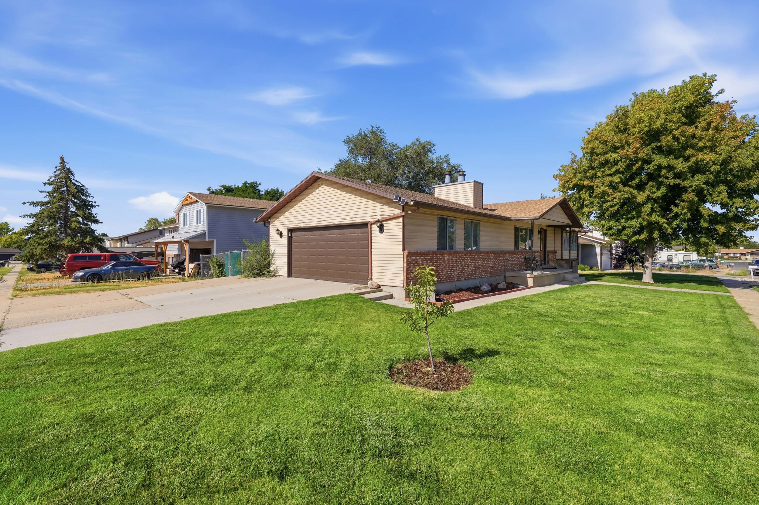 Ranch-style residence featuring a prominent attached two-car garage with a brown door