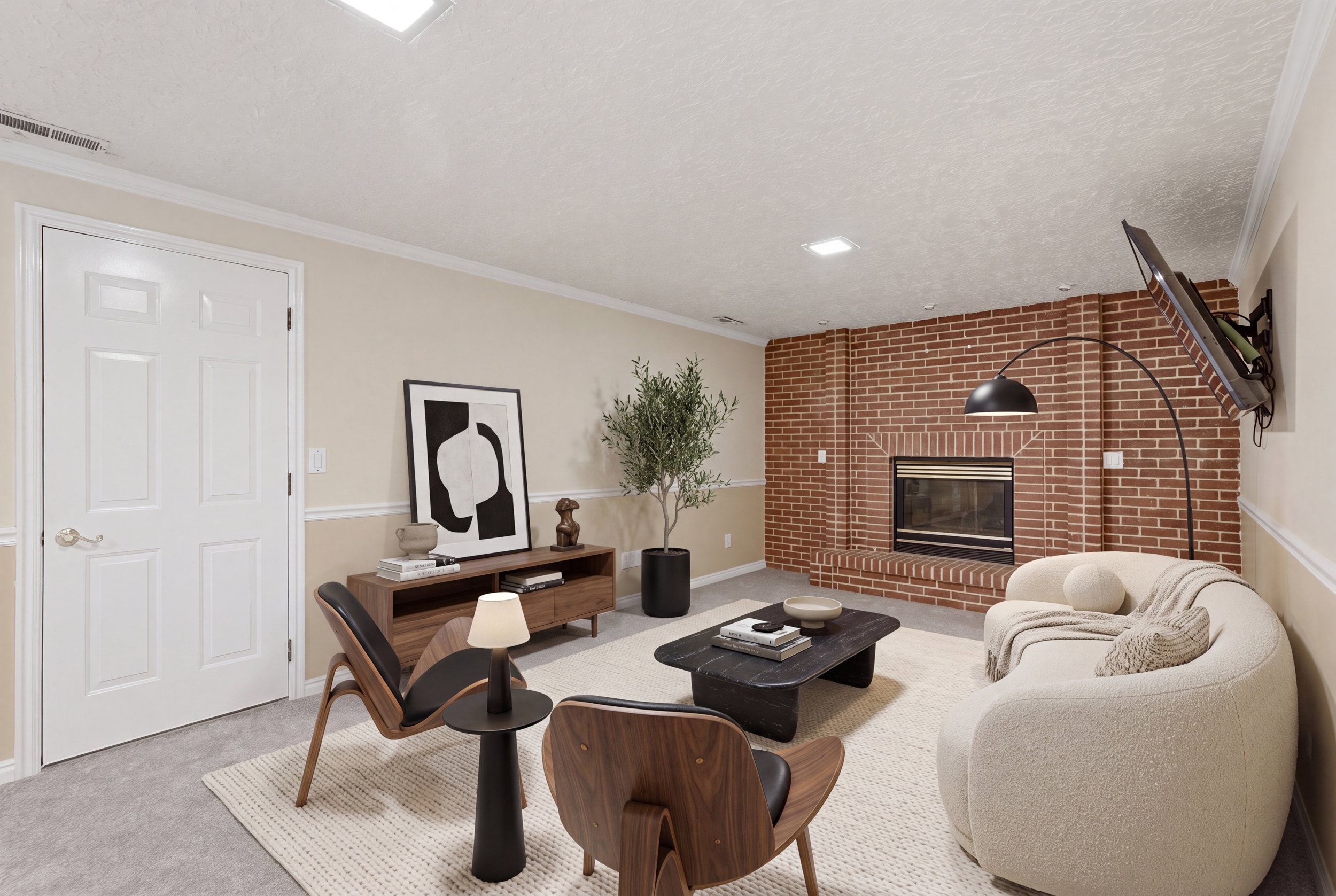 Living area featuring a brick fireplace with a black insert, light-toned walls with wainscoting, recessed ceiling lighting, and gray carpeting