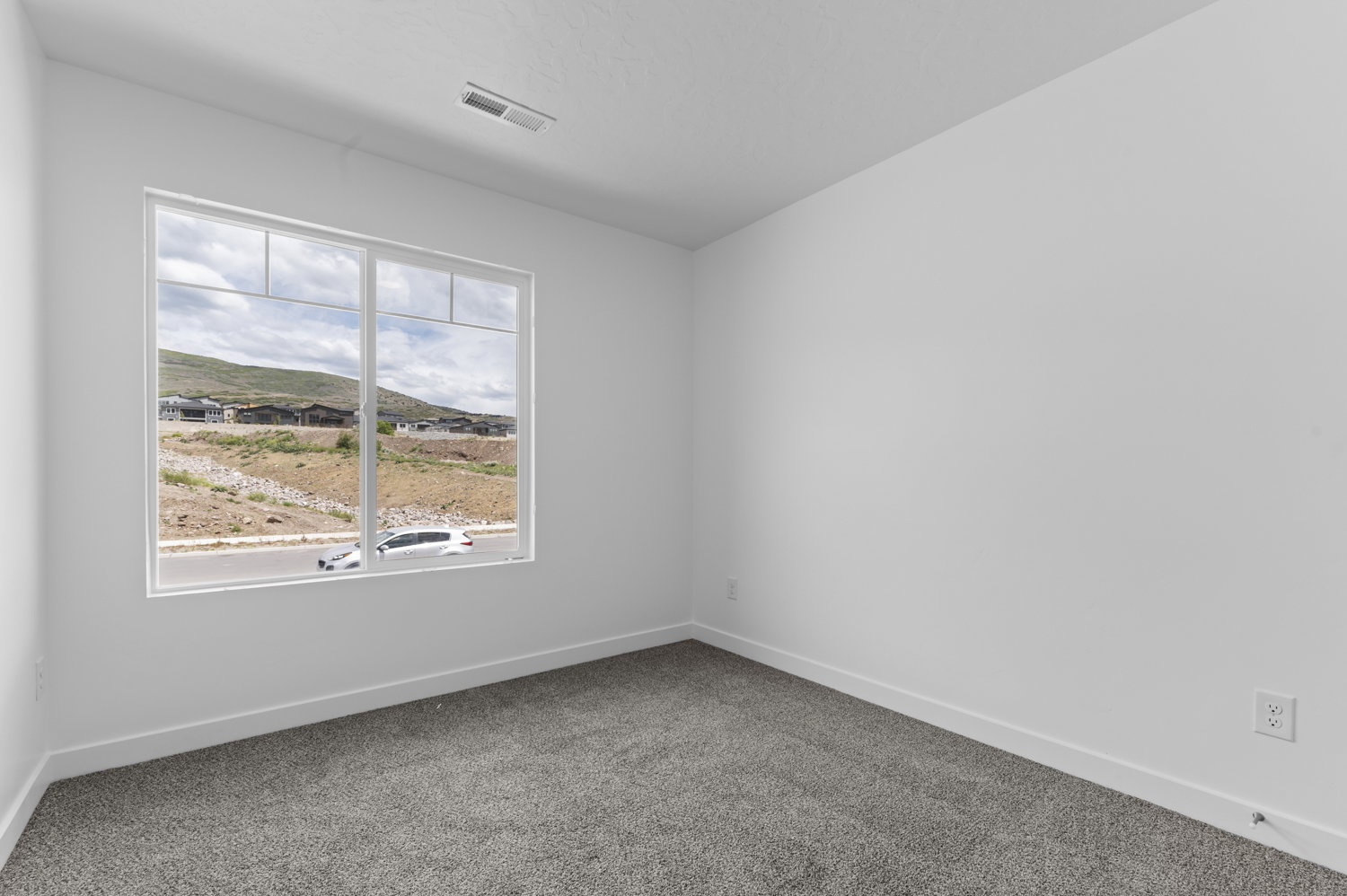 Spacious interior room with neutral carpeting and white wall finishes