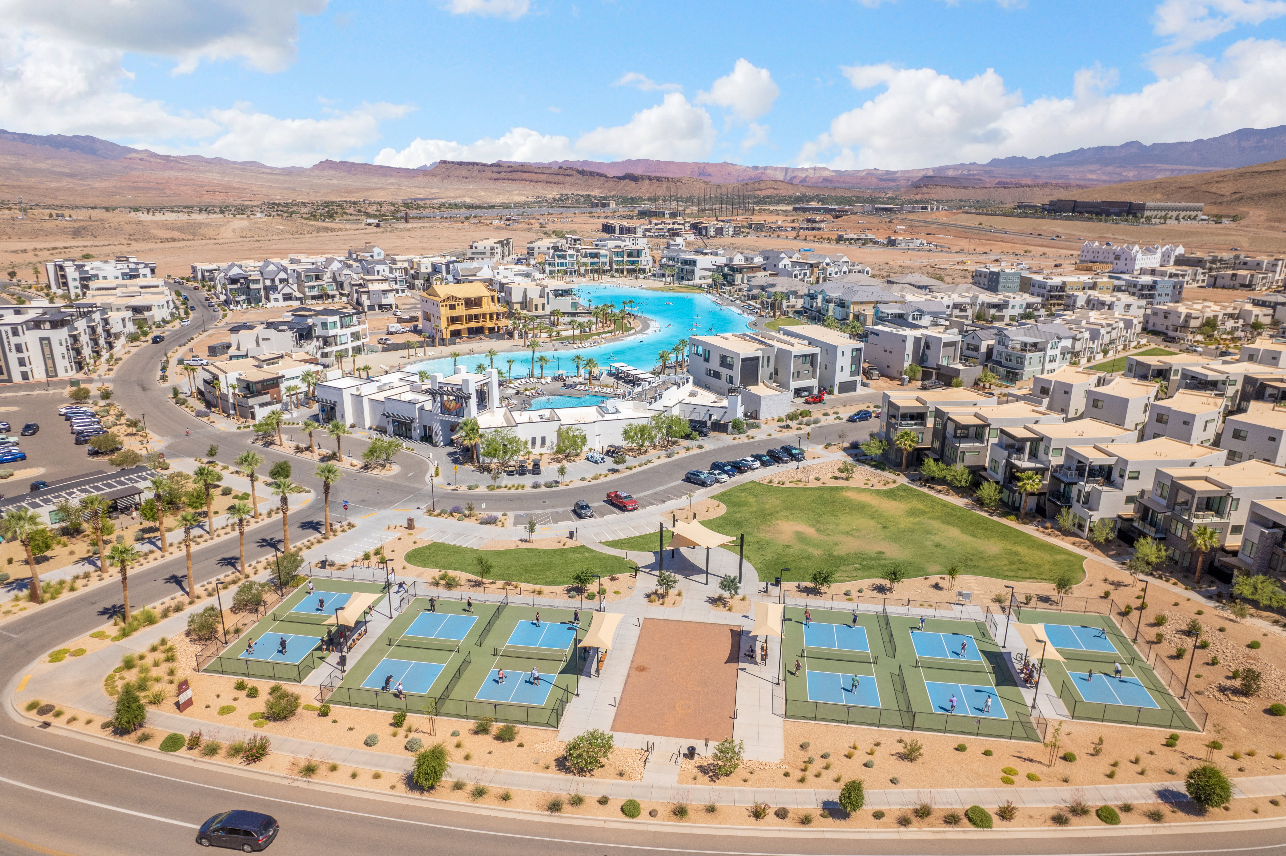 Aerial perspective showcasing a community with a large lagoon, multiple residential buildings, and a dedicated recreational area
