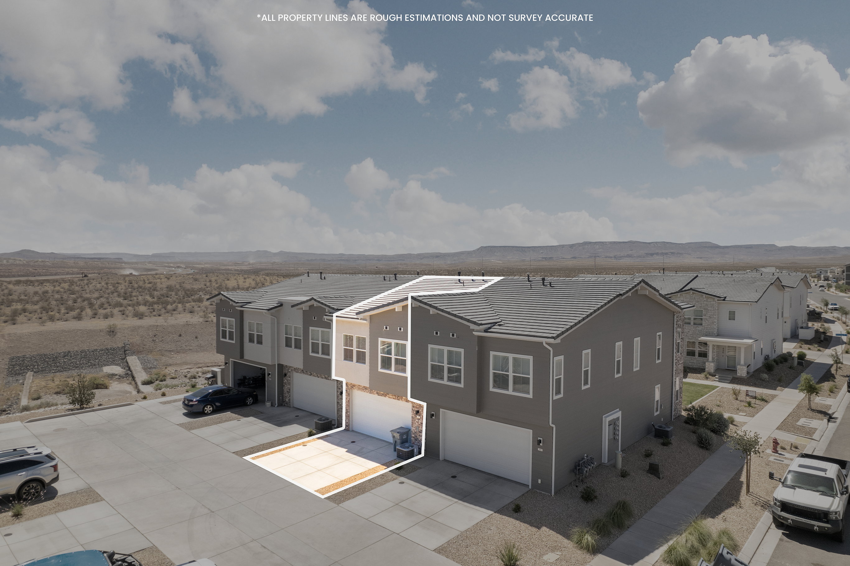 Modern townhome exterior featuring an attached garage, paved driveway, and stone accents