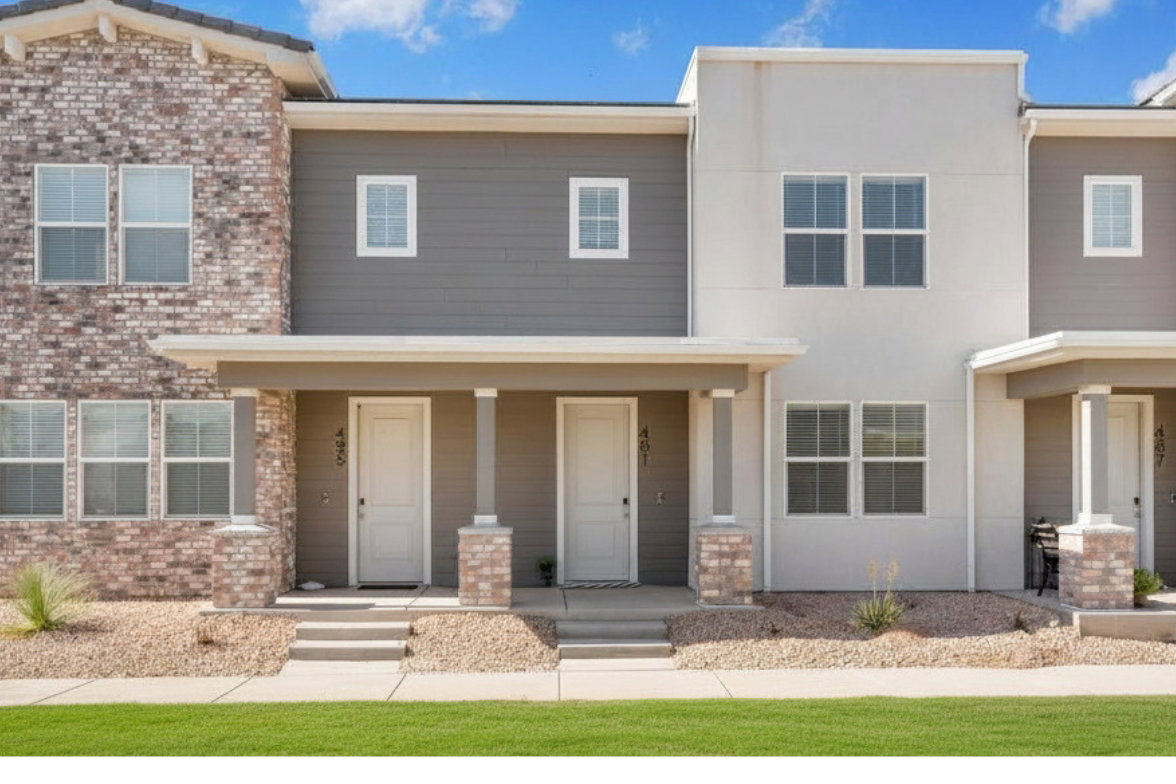Contemporary multi-unit residence featuring varied exterior finishes including brick veneer, horizontal siding, and smooth stucco