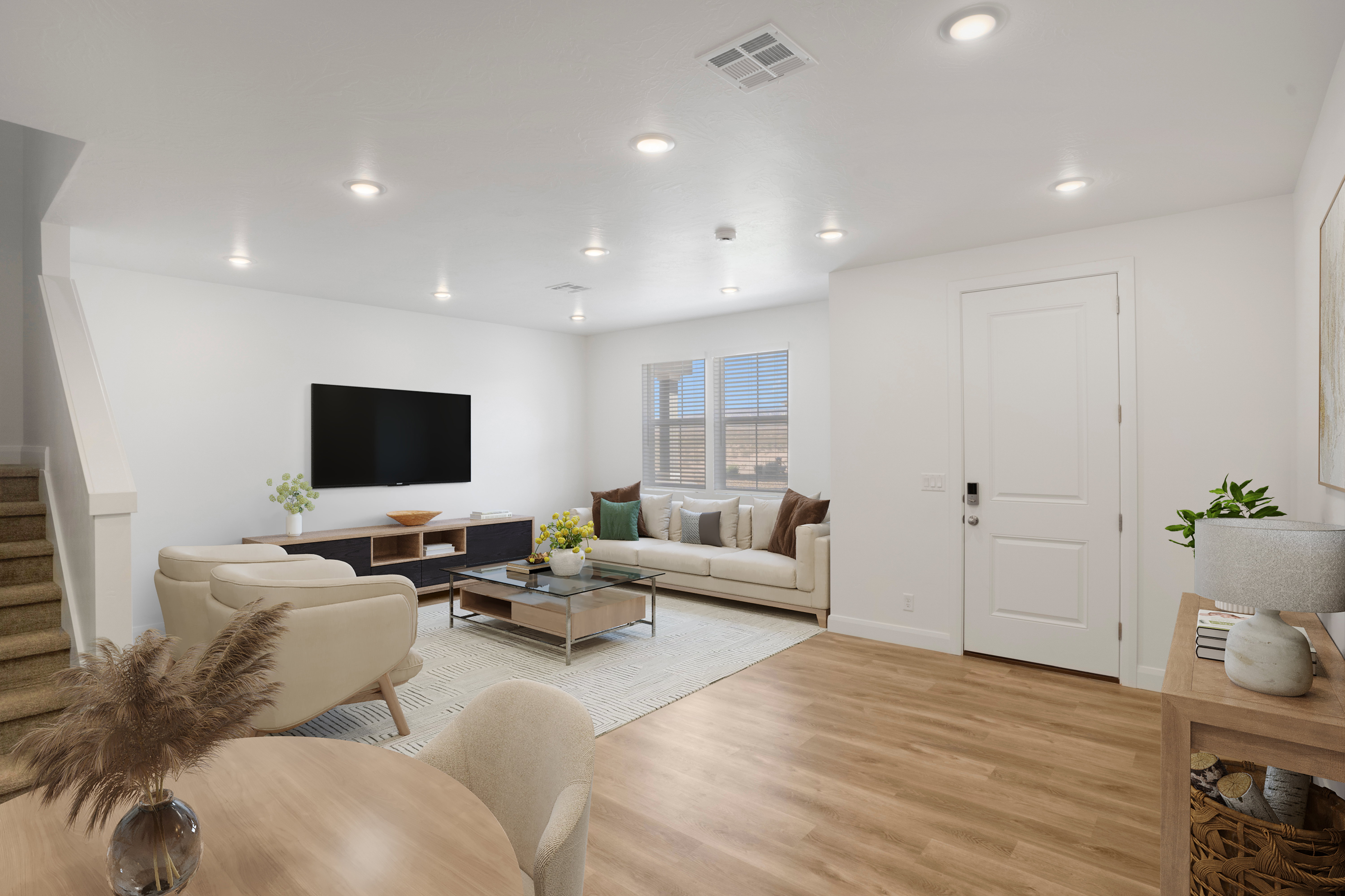 Open concept living area featuring wood-finish flooring, recessed lighting, white baseboards, and a staircase with carpeted treads