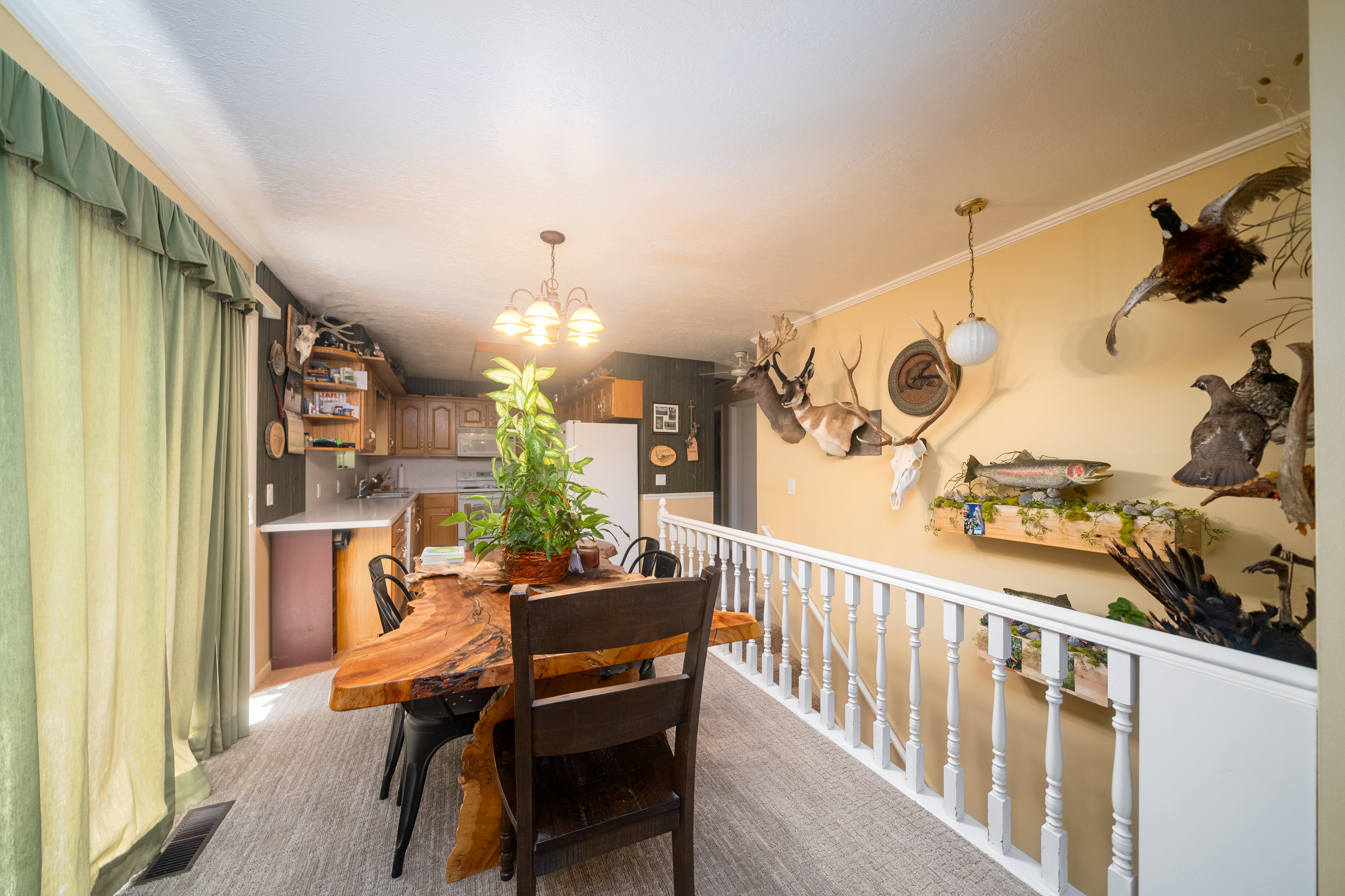 Dining area featuring wood-finish flooring, a wood live-edge dining table, and a contemporary chandelier