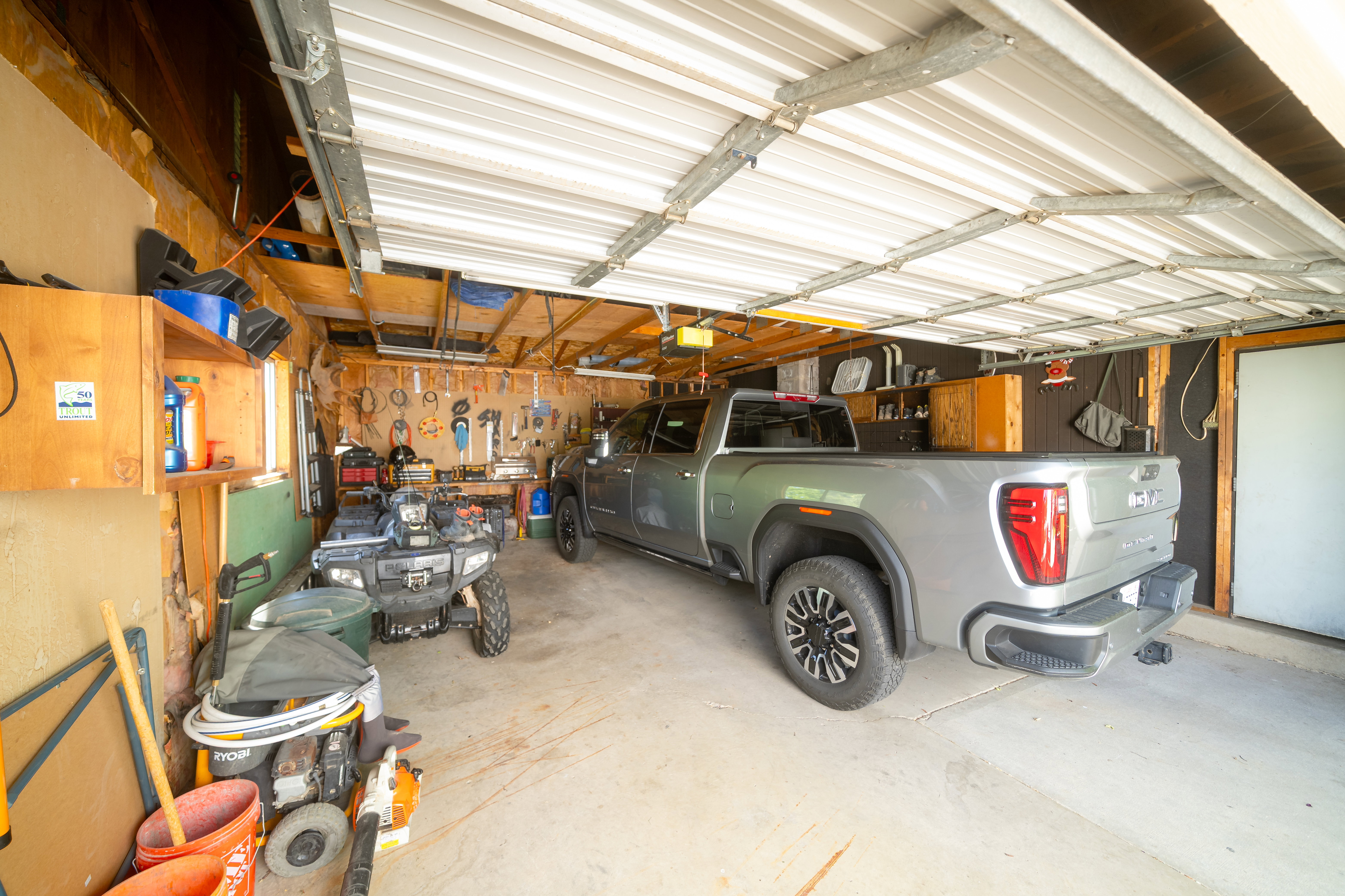 Garage space featuring a corrugated metal ceiling and concrete flooring