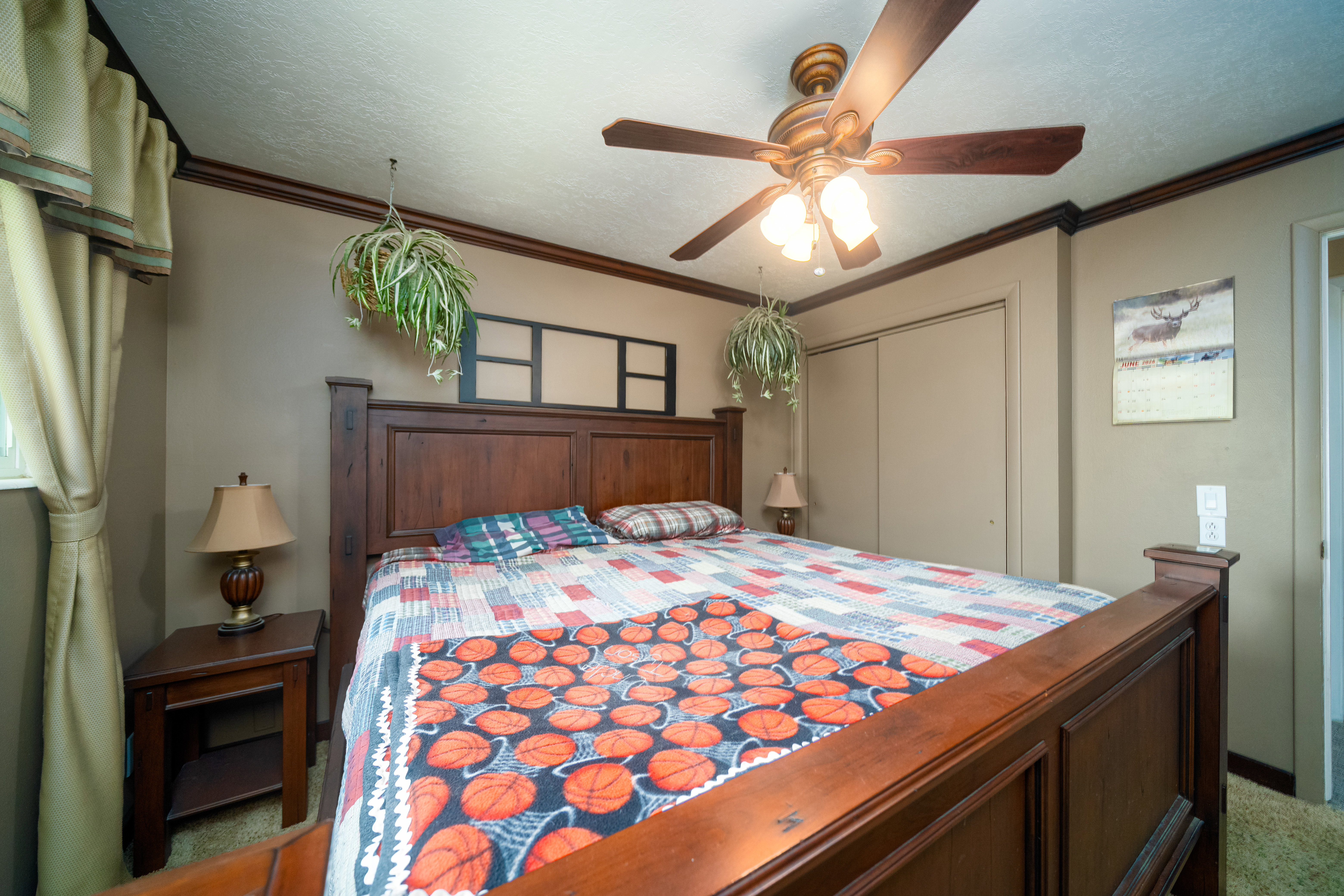 Bedroom featuring a ceiling fan, crown molding, double sliding closet doors, and wood-finish trim