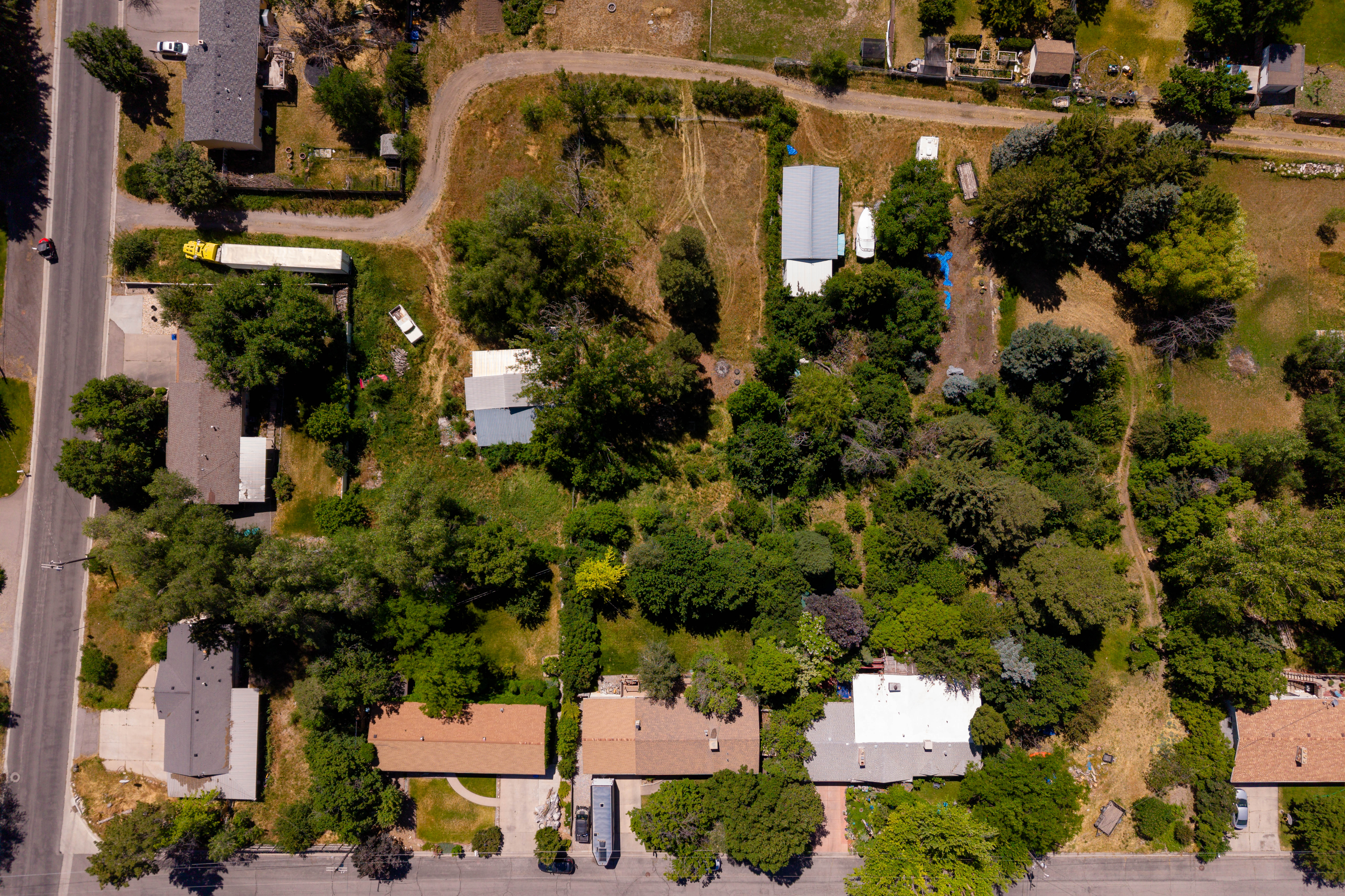 Aerial view showcasing a collection of residential properties with varied rooflines and surrounding mature trees