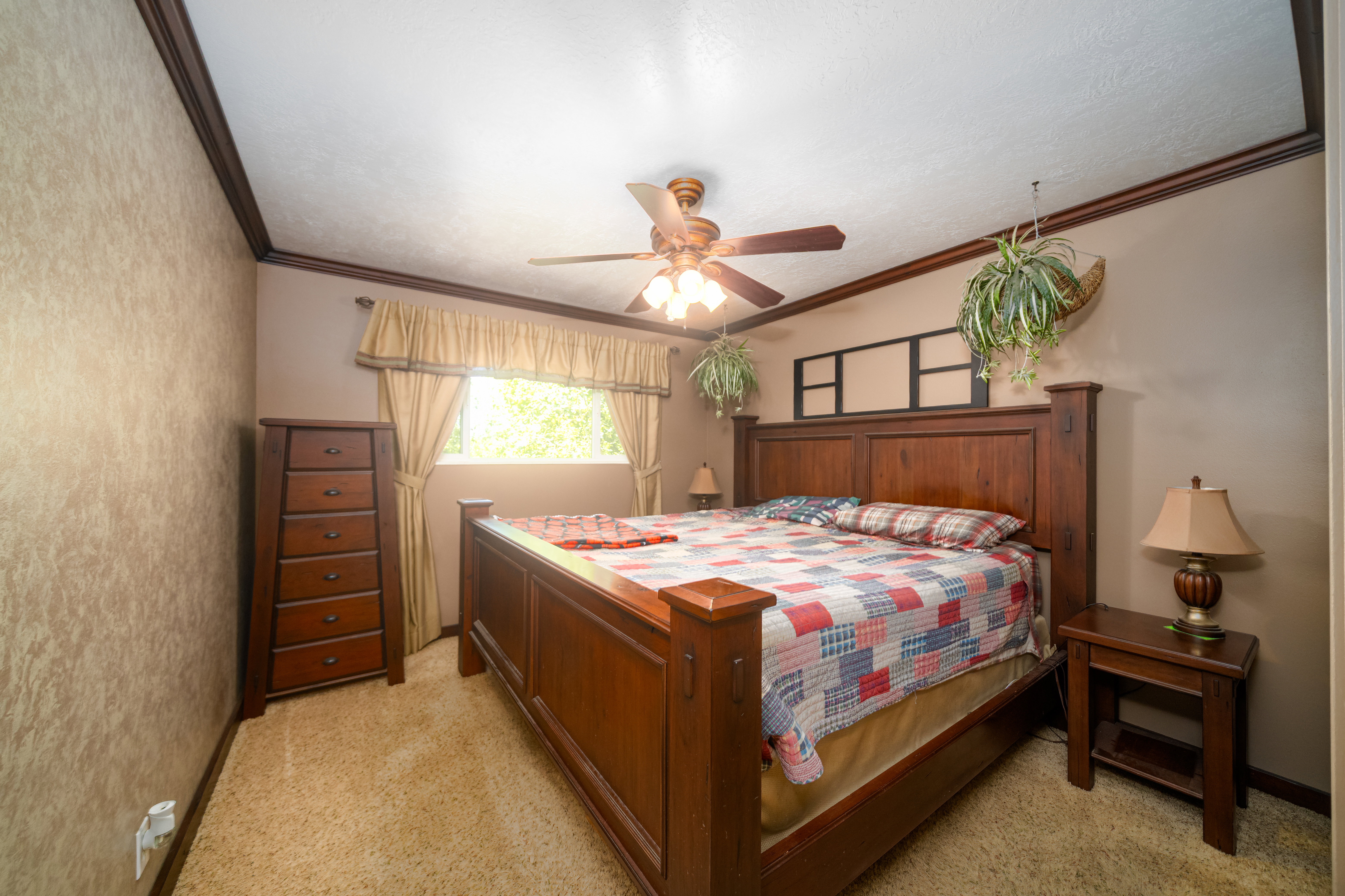 Bedroom featuring carpet flooring, a window with valance and drapes, crown molding, and a ceiling fan