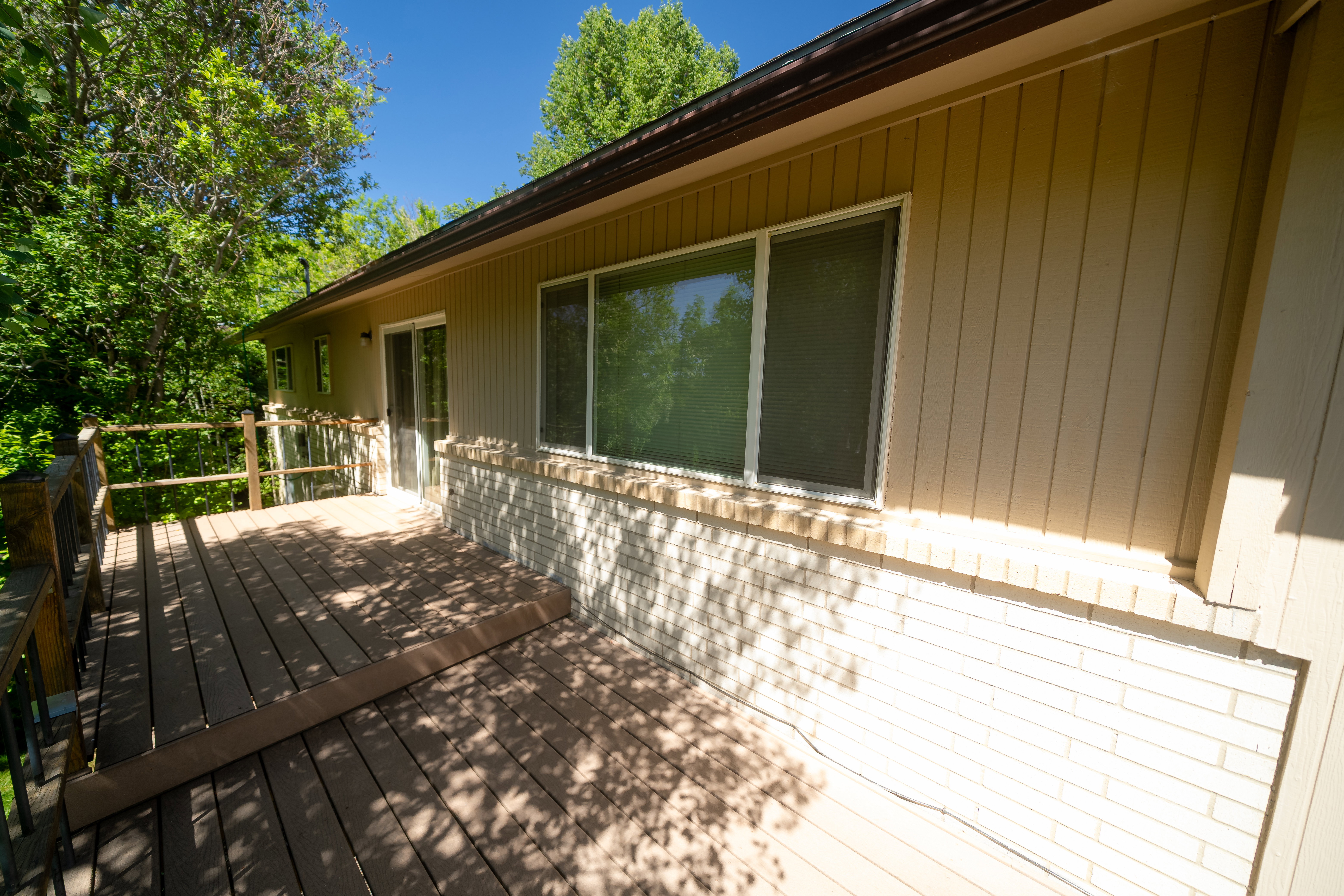 Spacious outdoor deck featuring wood-finish flooring and dark railings