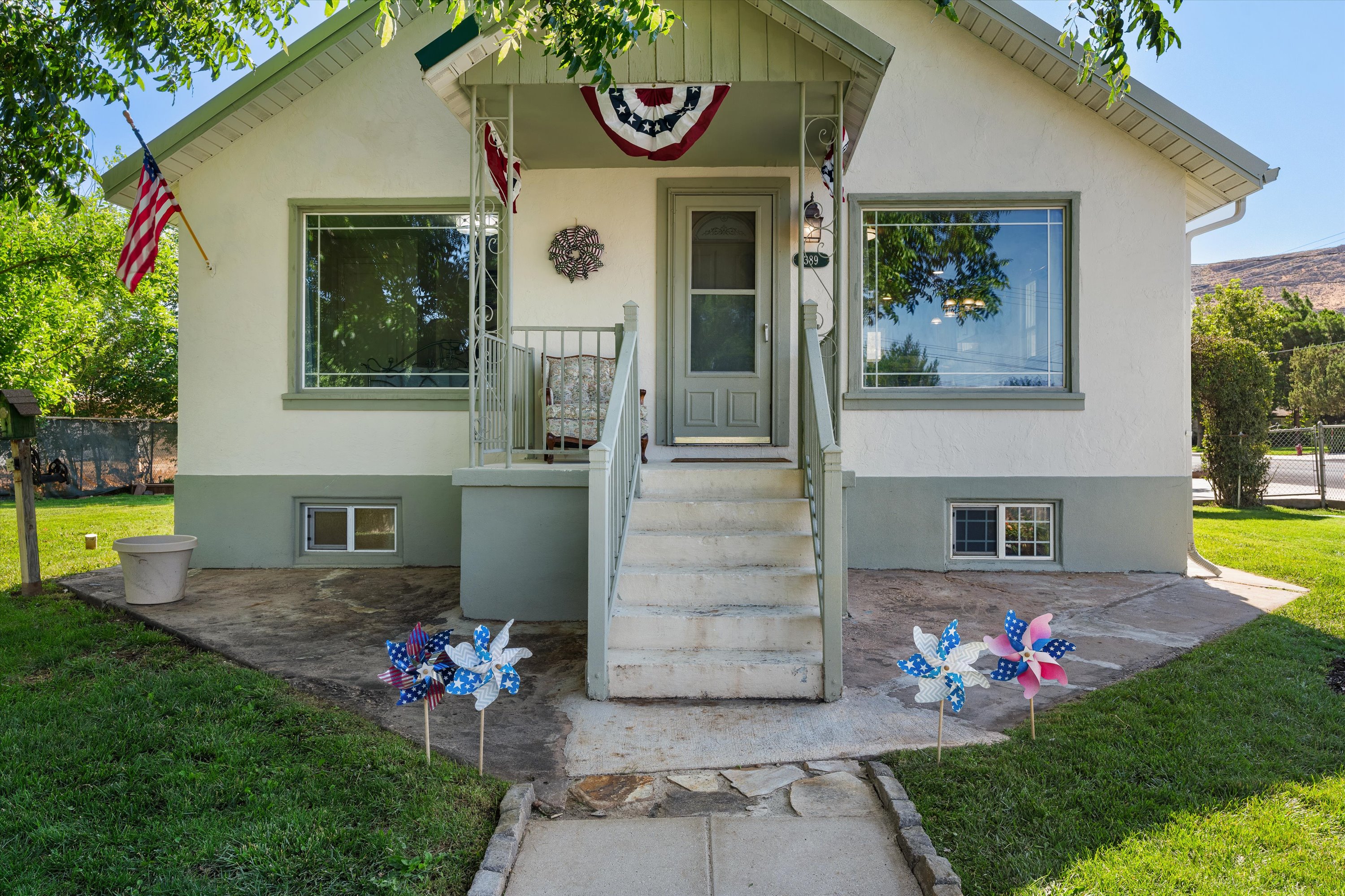 Stucco-finish exterior with a covered front porch featuring a multi-pane glass entry door