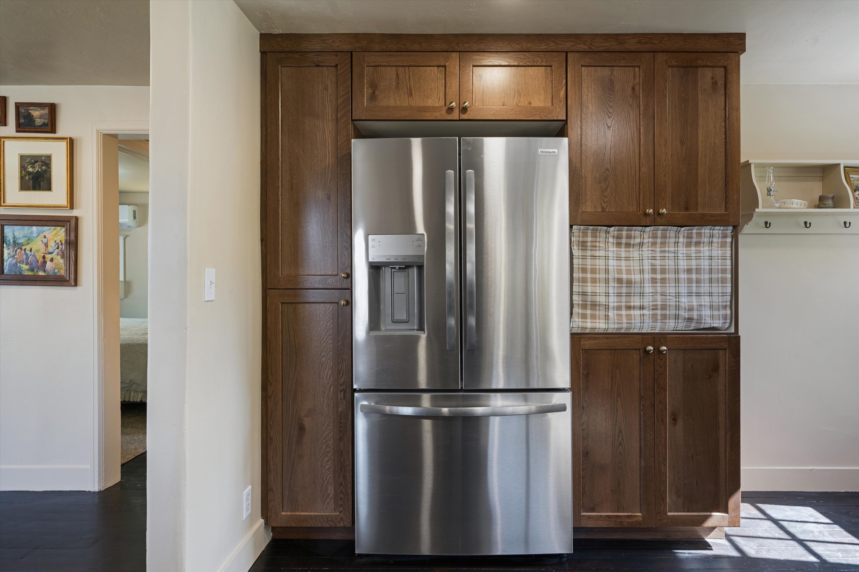 Stainless steel French-door refrigerator integrated with wood-finish cabinetry