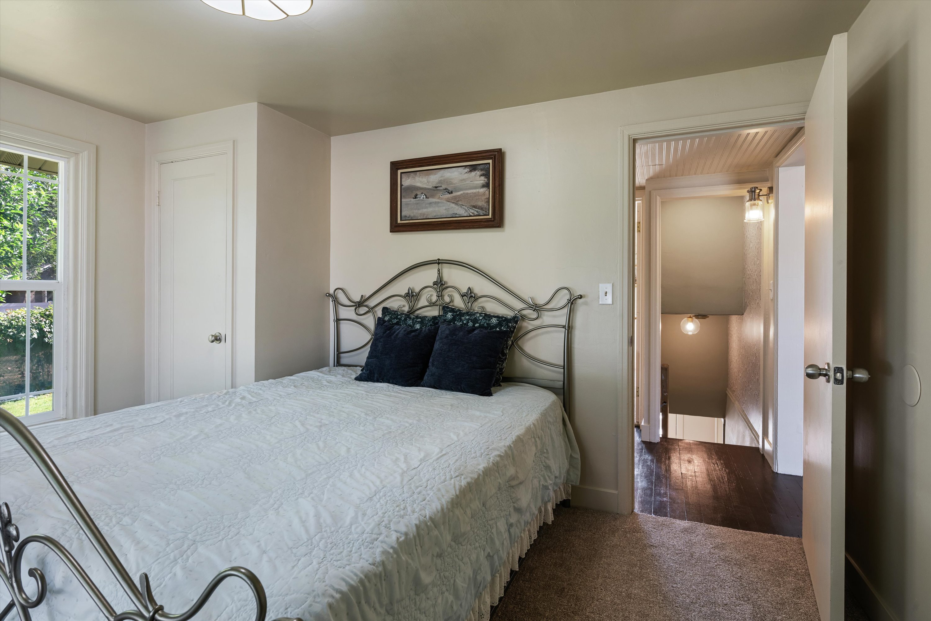 Carpeted room with a double-pane window, white trim, and a flush-mount ceiling light