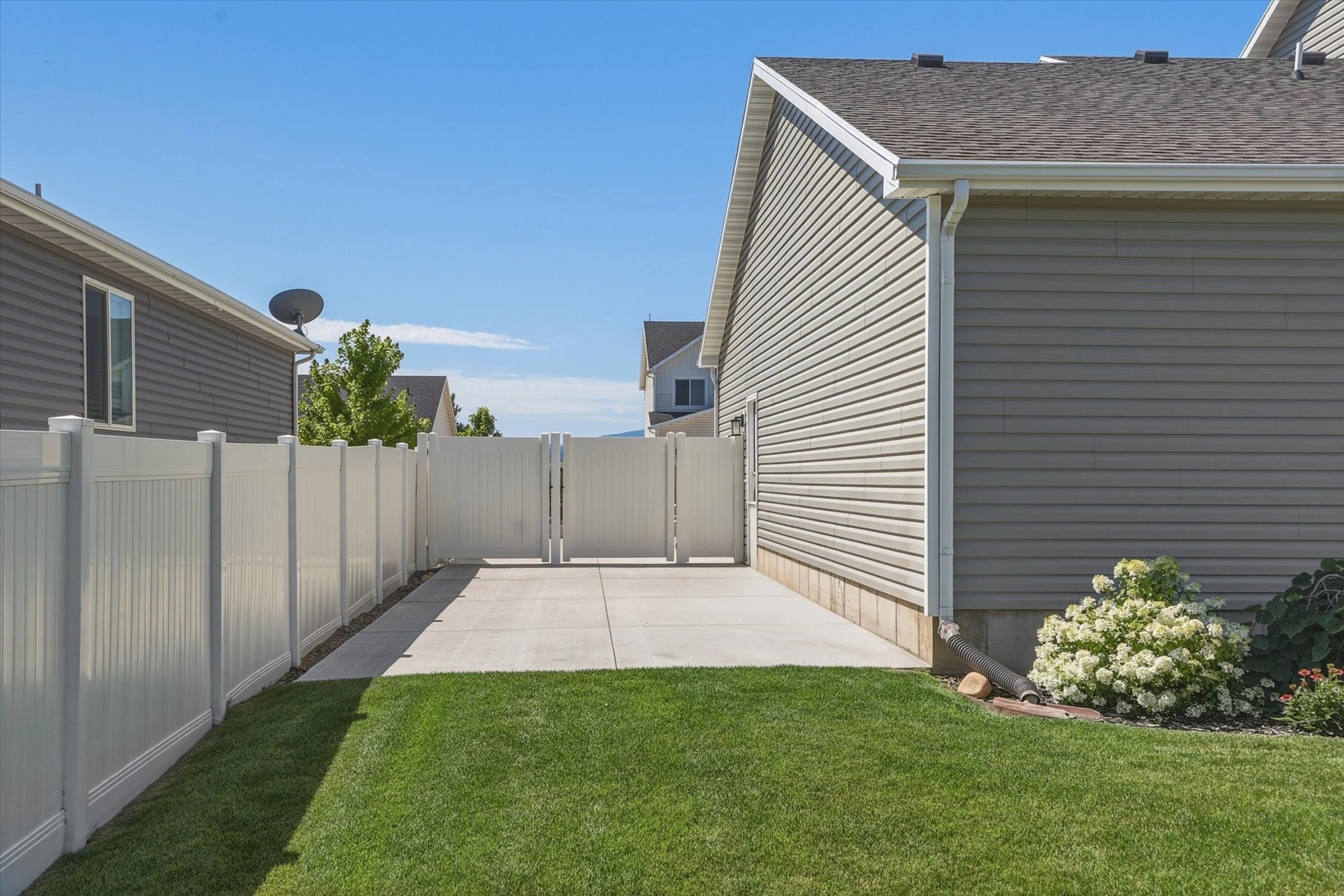 Lawn area featuring a concrete RV Parking patio, full privacy fencing, and exterior vinyl siding