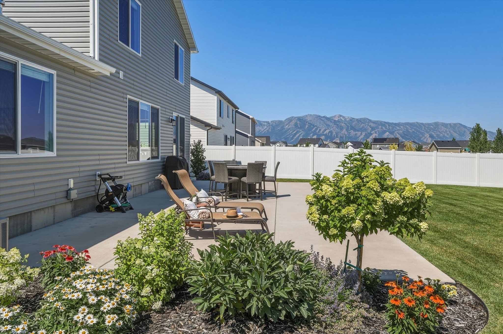 Expansive concrete patio with integrated landscaping beds