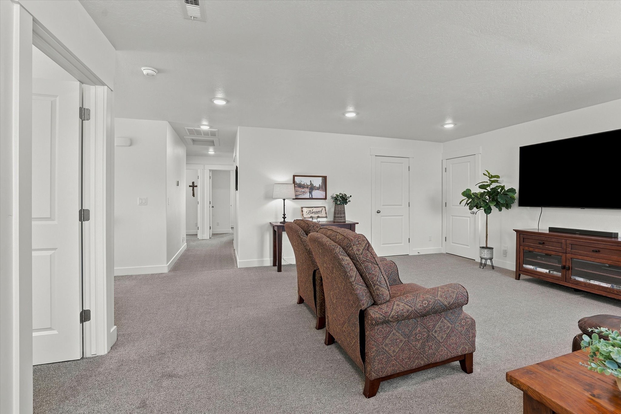 Spacious carpeted living area featuring recessed lighting, white trim, and a built-in media console