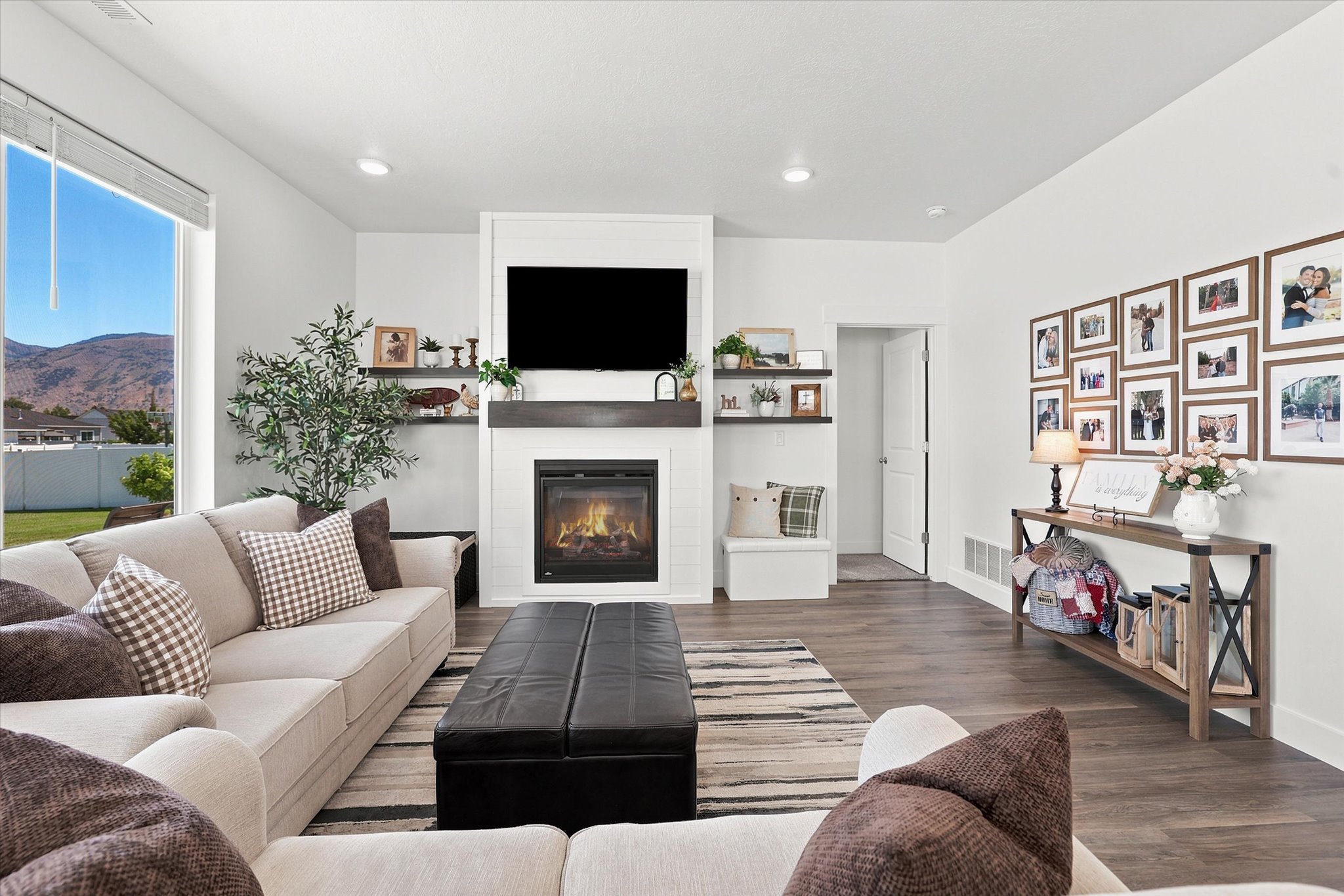 Living area featuring a modern fireplace with a dark wood mantle, recessed lighting, and LVP wood-finish flooring