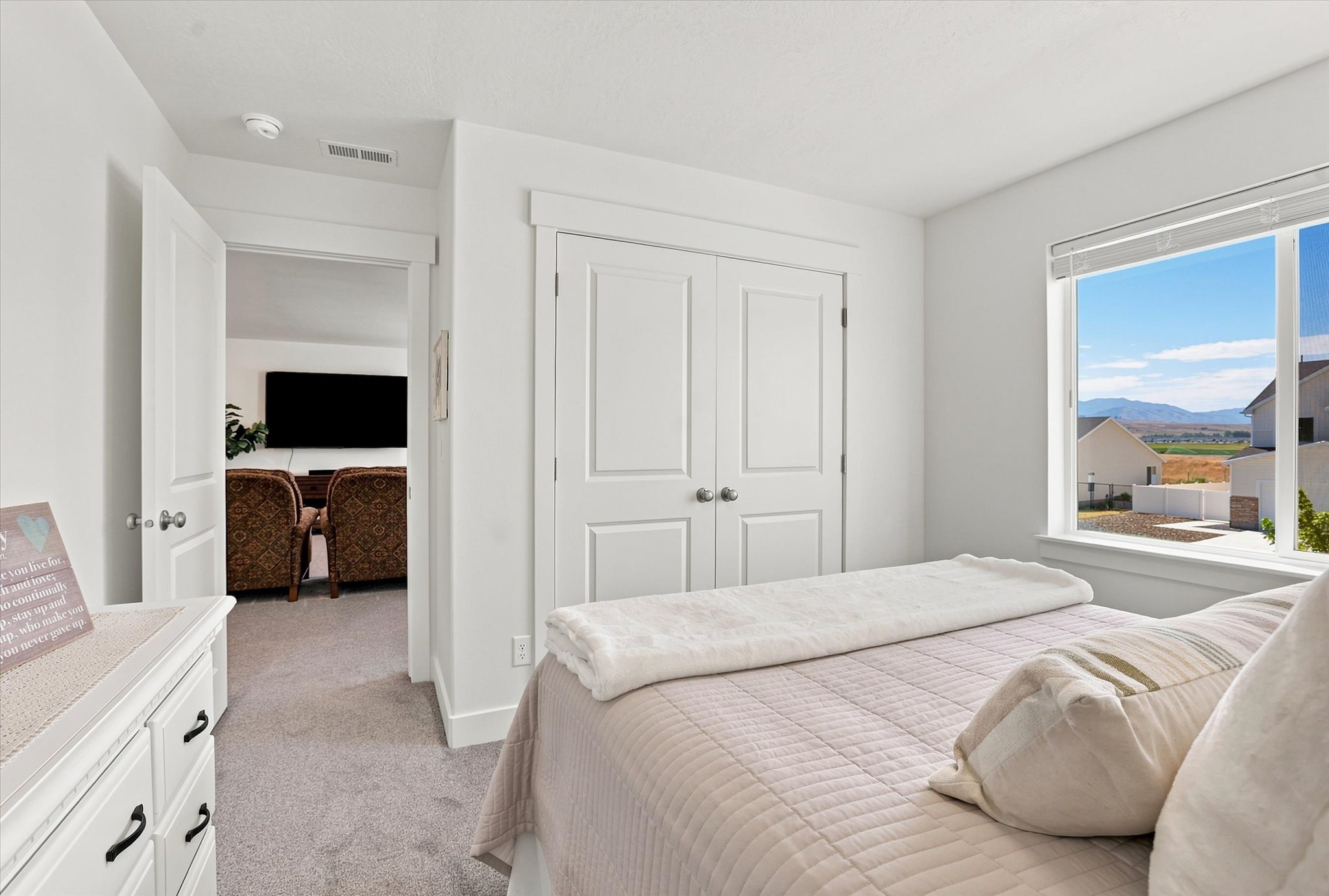Bright room featuring a large window, white trim, and a mountain backdrop