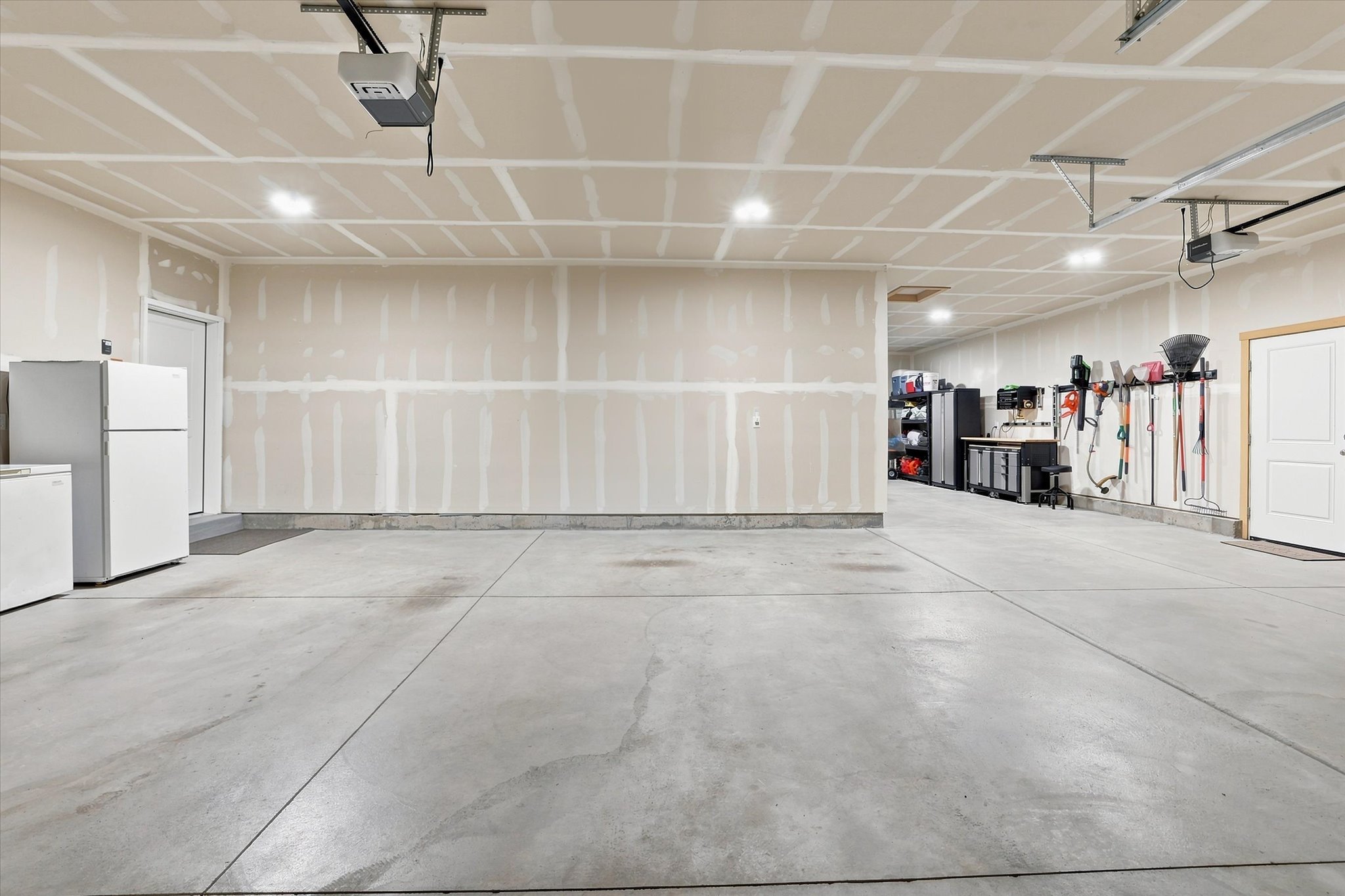 Spacious garage featuring concrete flooring and exposed ceiling joists