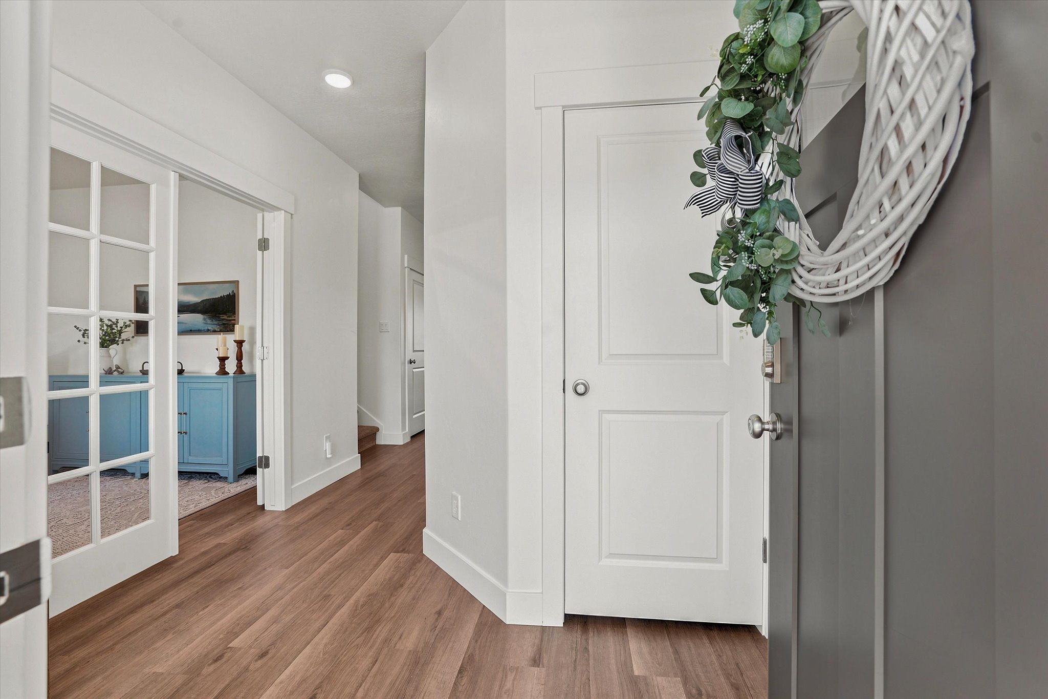 Entryway featuring LVP wood-finish flooring, white trim, recessed lighting, and French doors leading to an additional room