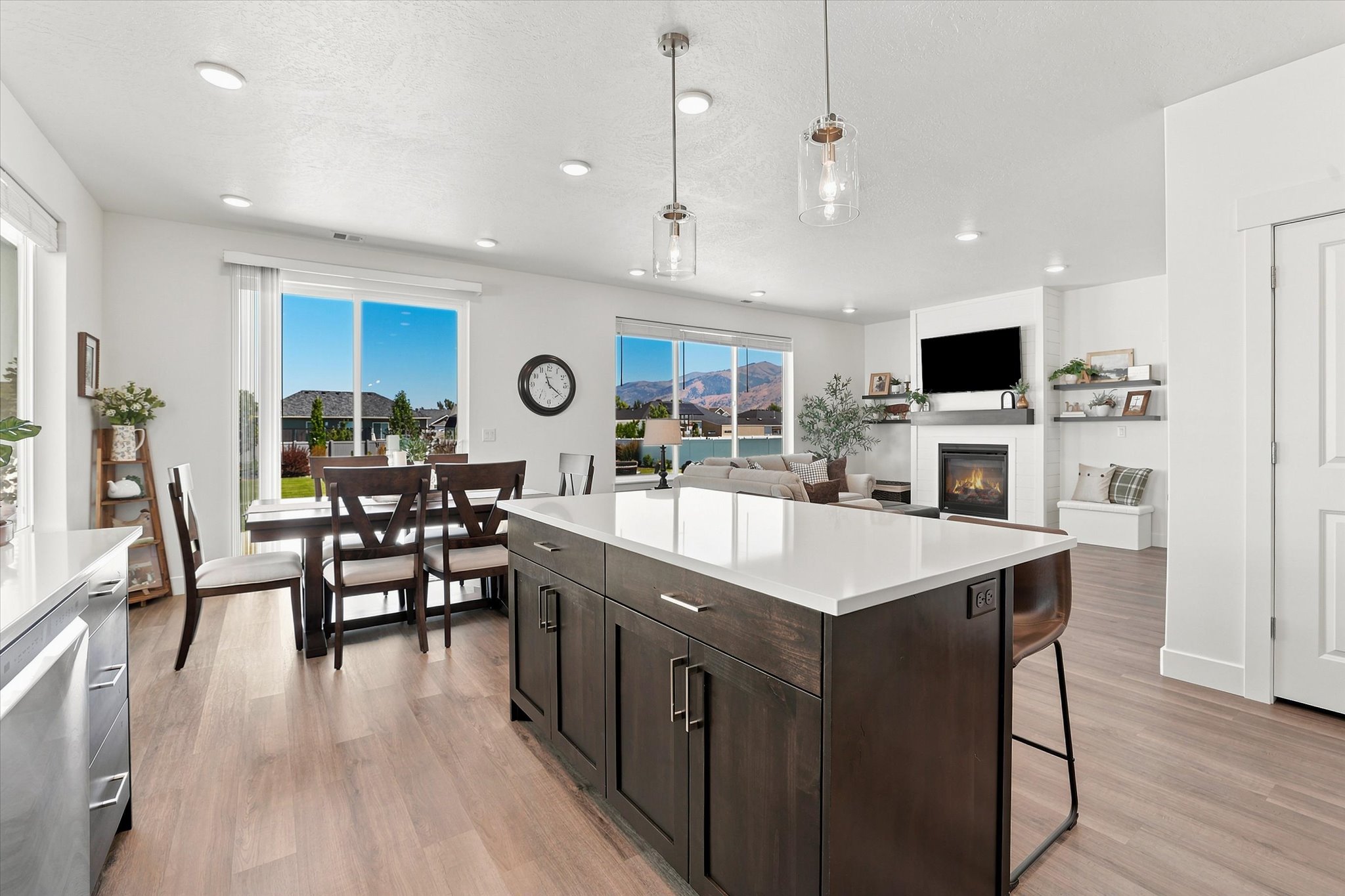 Open-concept living space featuring a central kitchen island with a white countertop, recessed lighting, and wood-finish flooring