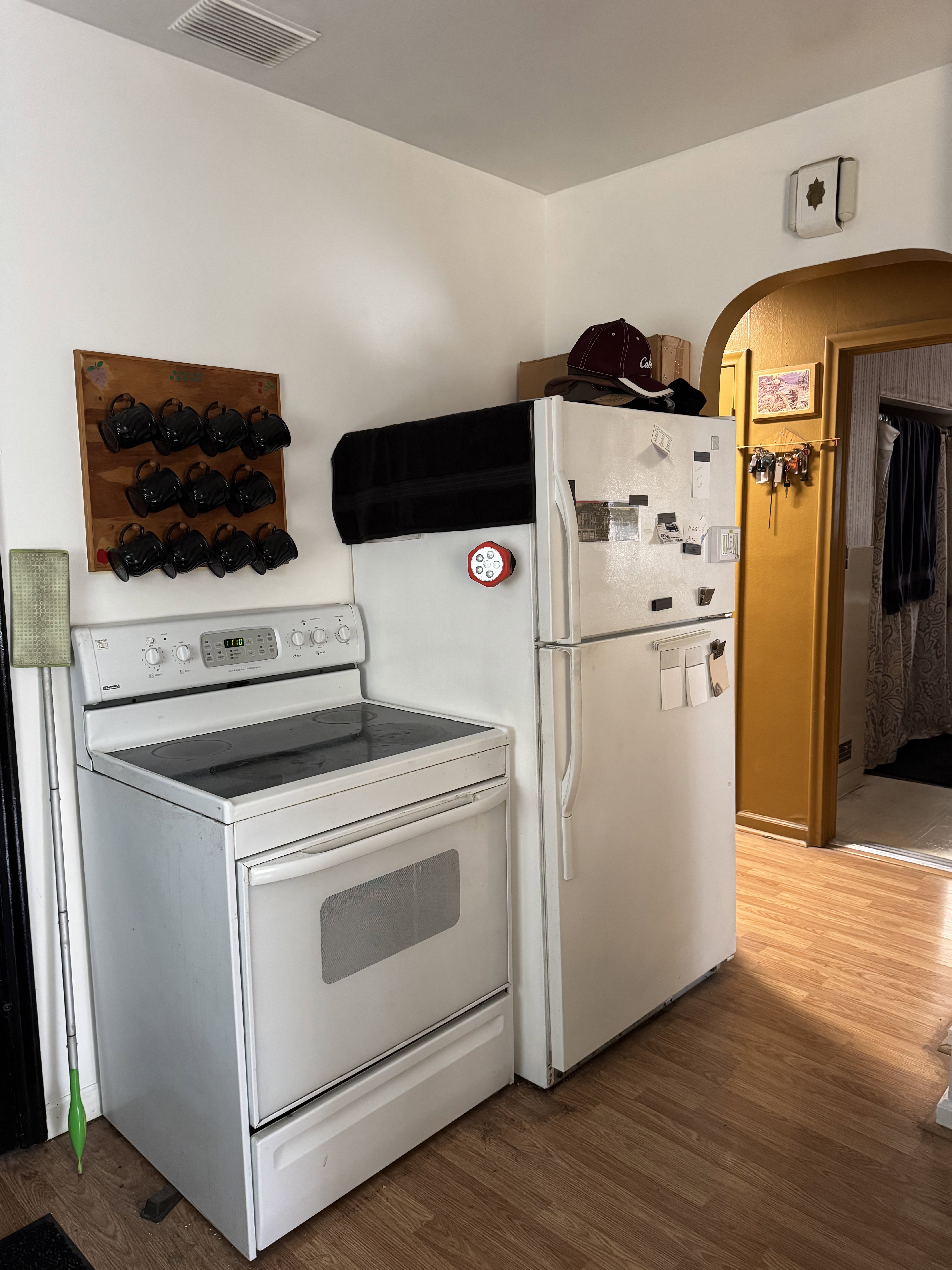 Kitchen area featuring white appliances, including a smooth-top electric range and a top-freezer refrigerator