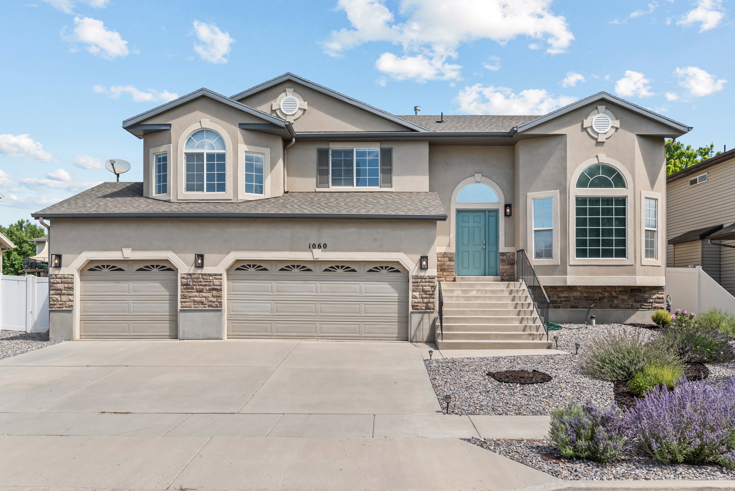 Stucco exterior with stone accents and a two-car garage