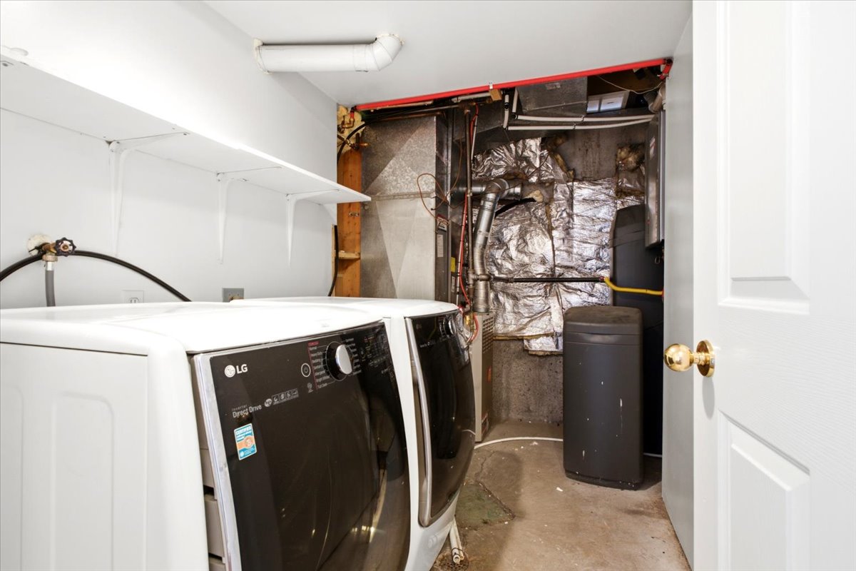 Utility area with white shelving and a water treatment system