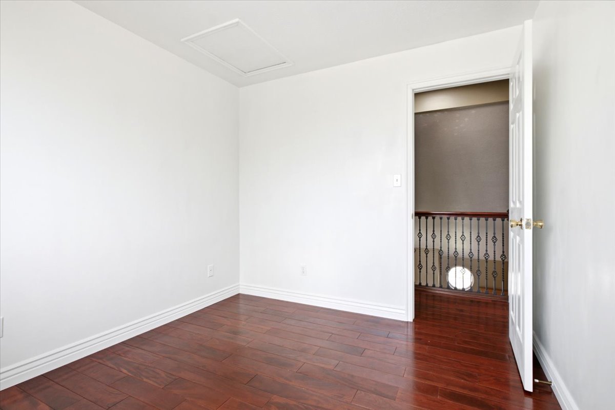 Room featuring dark wood-finish flooring, white walls, and white baseboards