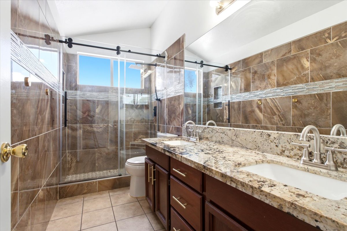 Dual vanity with stone-finish countertop, under-mount sinks, and brushed nickel faucets