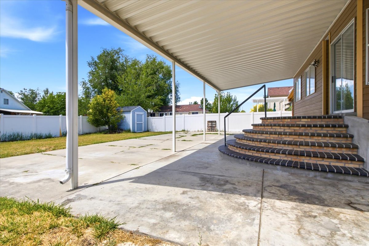 Covered patio with a corrugated metal roof supported by white columns