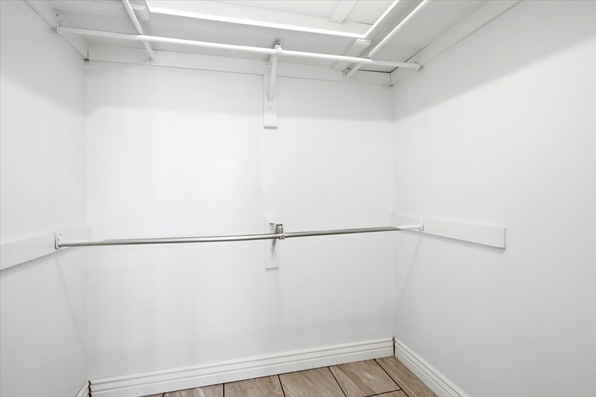 Closet featuring white walls, white trim, and wood-finish flooring