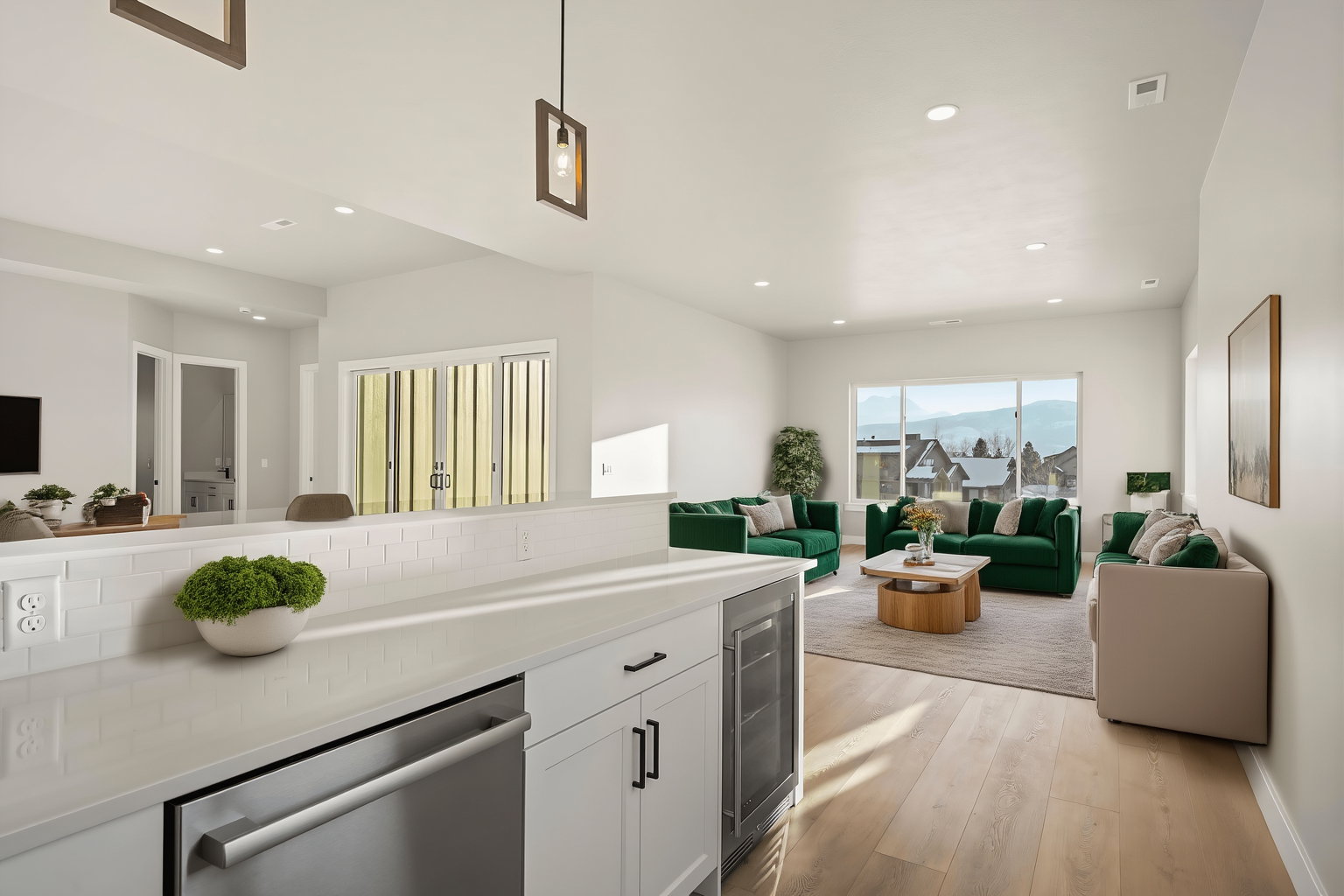 Open-concept living space with light wood-finish flooring and recessed lighting