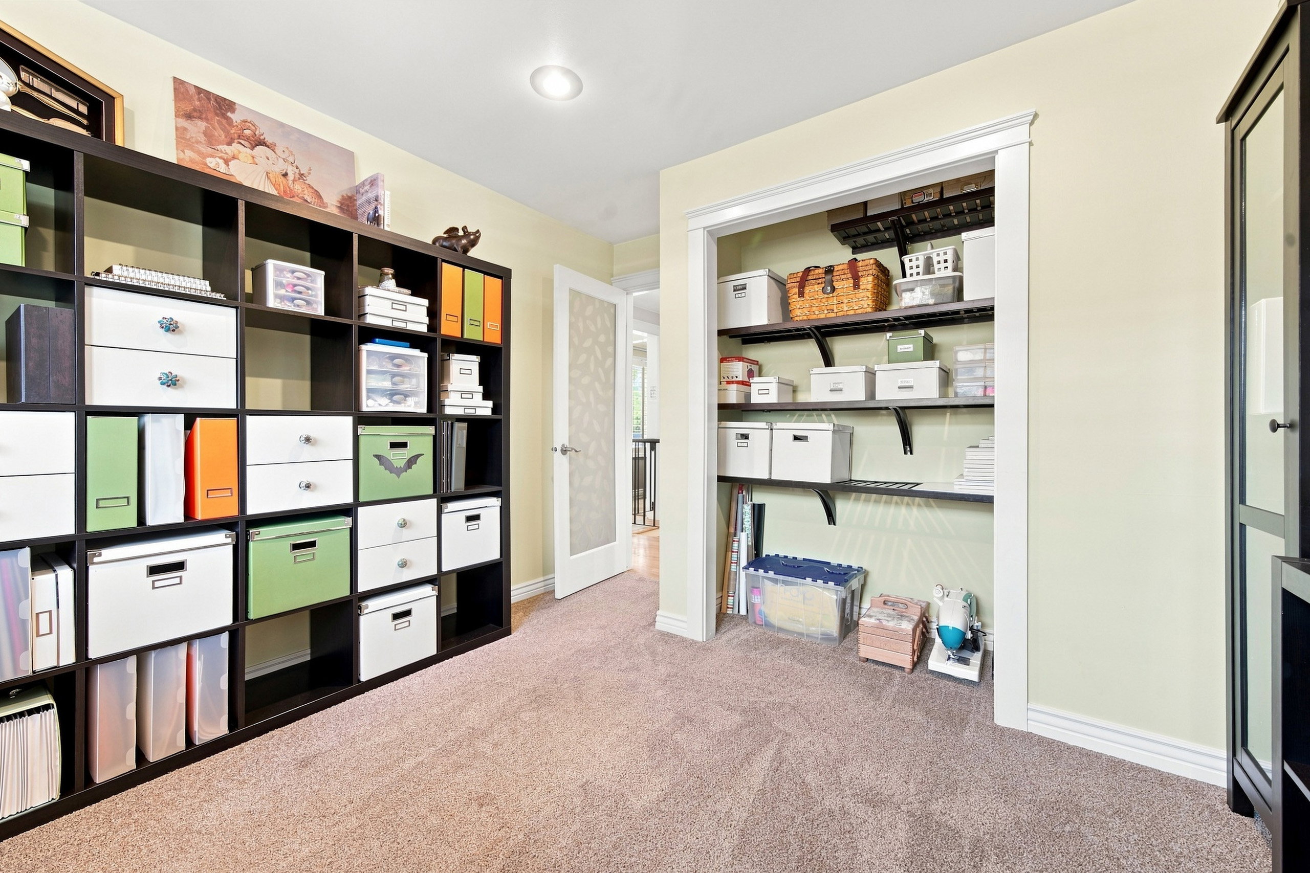 Versatile interior space featuring recessed lighting, plush carpet flooring, a built-in closet with adjustable shelving, and a glass-paneled interior door