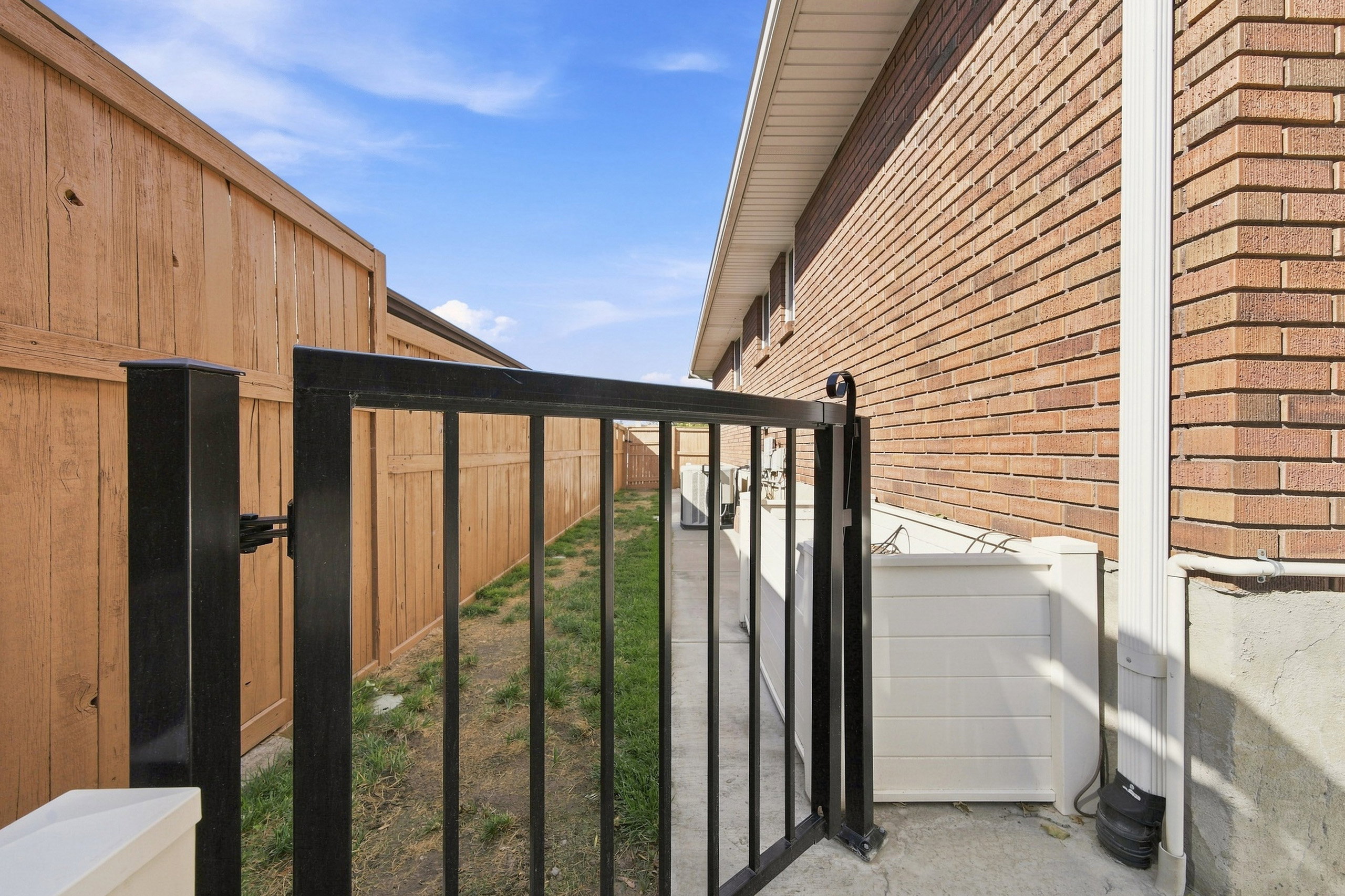 Black metal gate providing entry to the side yard