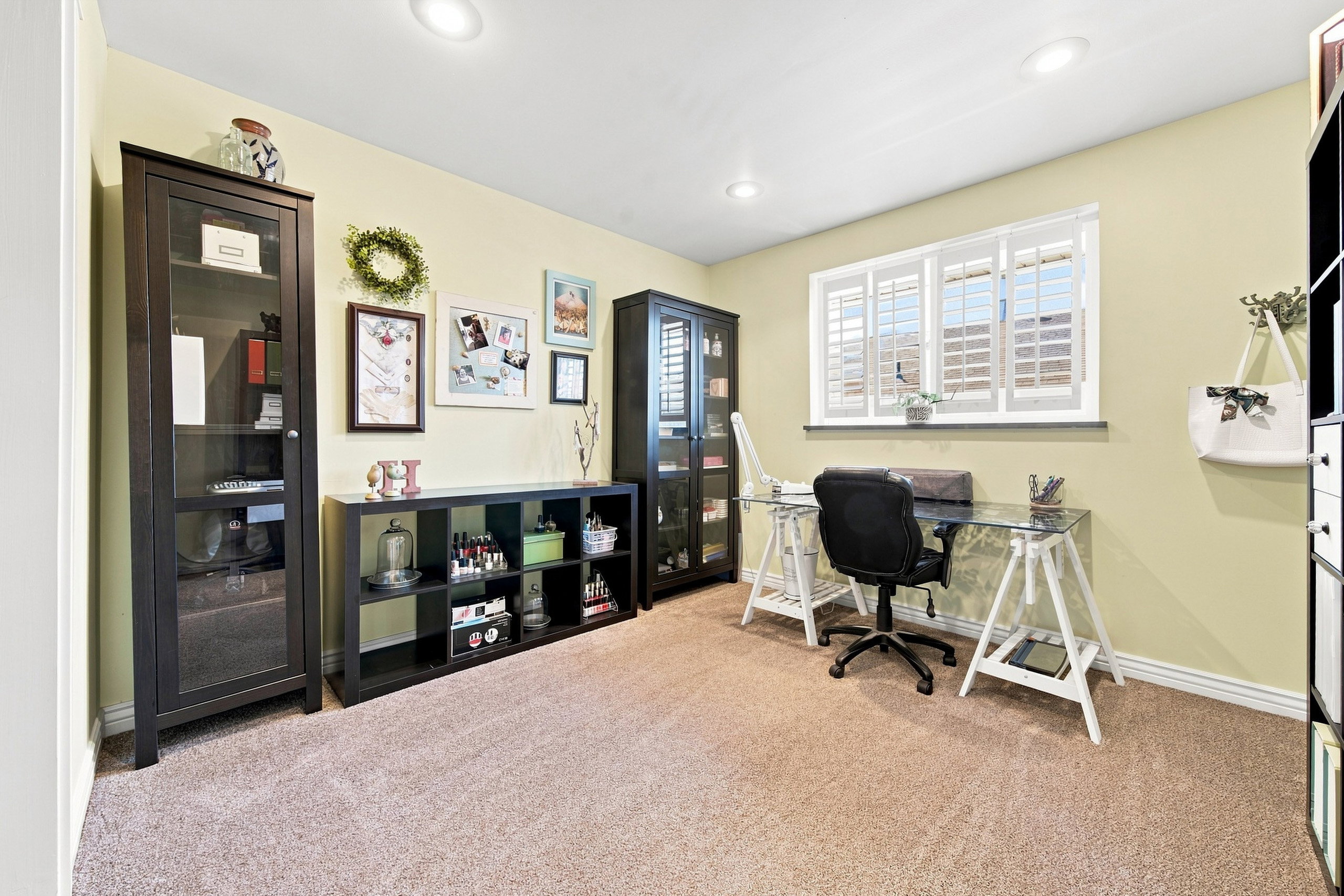 Carpeted room featuring recessed lighting and a window with white shutters
